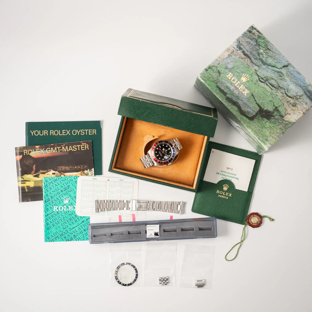 Lieferumfang zugehörig zu der Rolex GMT-Master II 16710 mit der blau-roten Pepsi-Lünette am Jubilee-Armband bestehend aus Box mit Umkarton, originalen Papieren, Rolex-Kalender, zugehörigen Booklets, einer zusätzlichen schwarzen Lünetten-Einlage, Hangtag und einem zusätzlichen Oyster-Armband