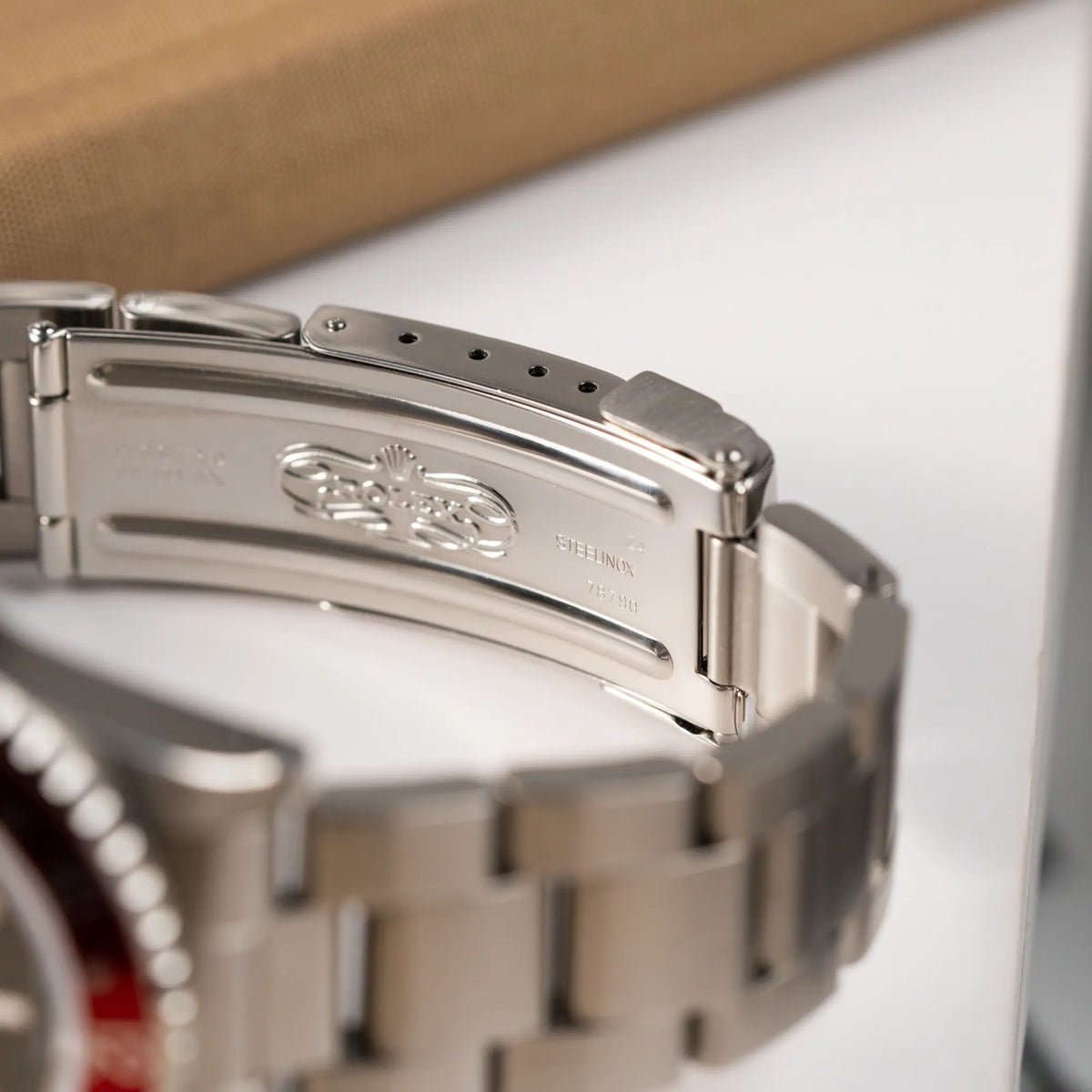 Produktfotografie zeigt das klassiche Rolex Logo im Inneren der Oyster-Faltschliesse der Rolex GMT Master 2 der Referenz 16710 aus der T-Serie mit blau-roter Pepsi-Lünette