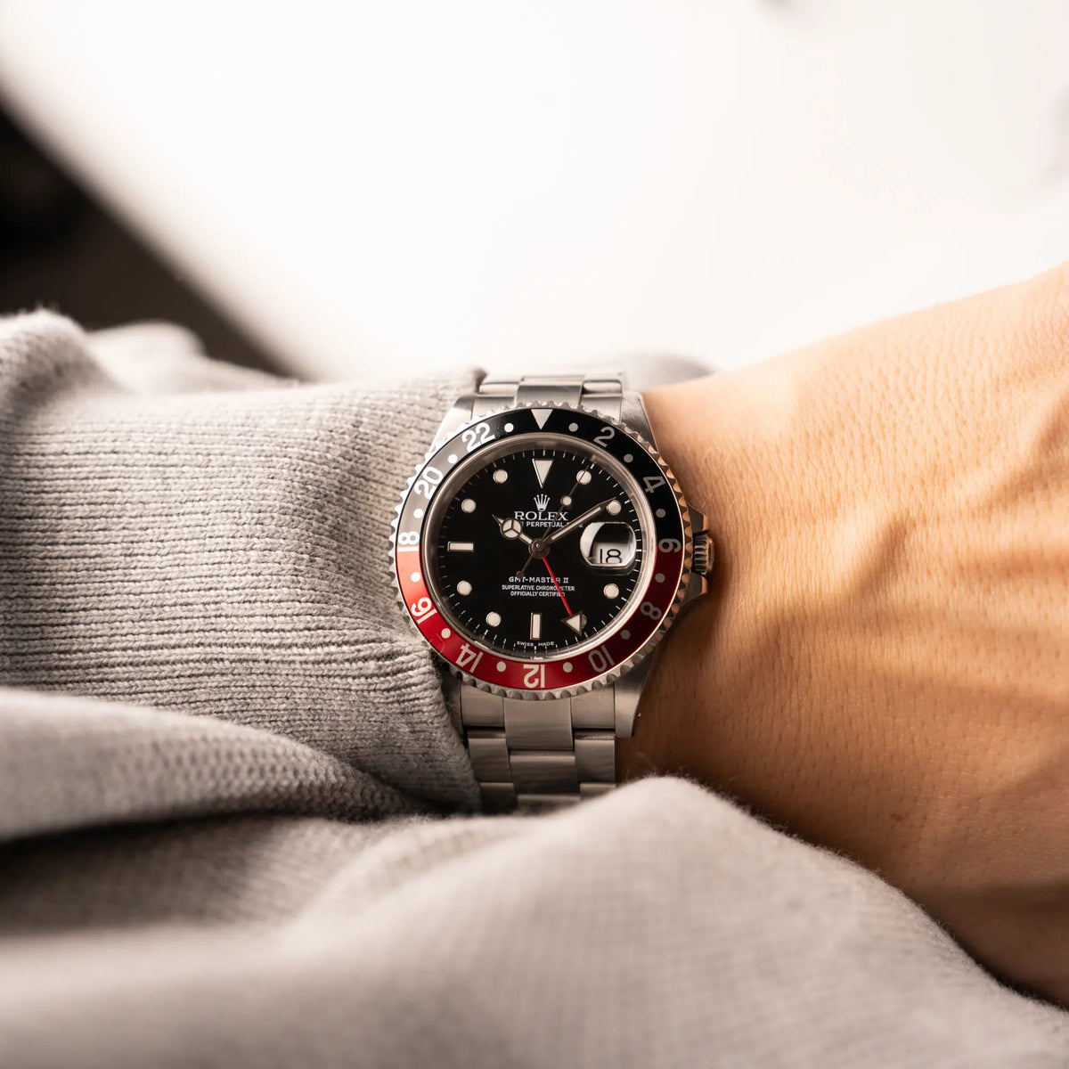 Mann trägt die Rolex GMT-Master II 16710 in Edelstahl mit schwarz-roten "Coke" Lünetten-Inlay an seinem Arm