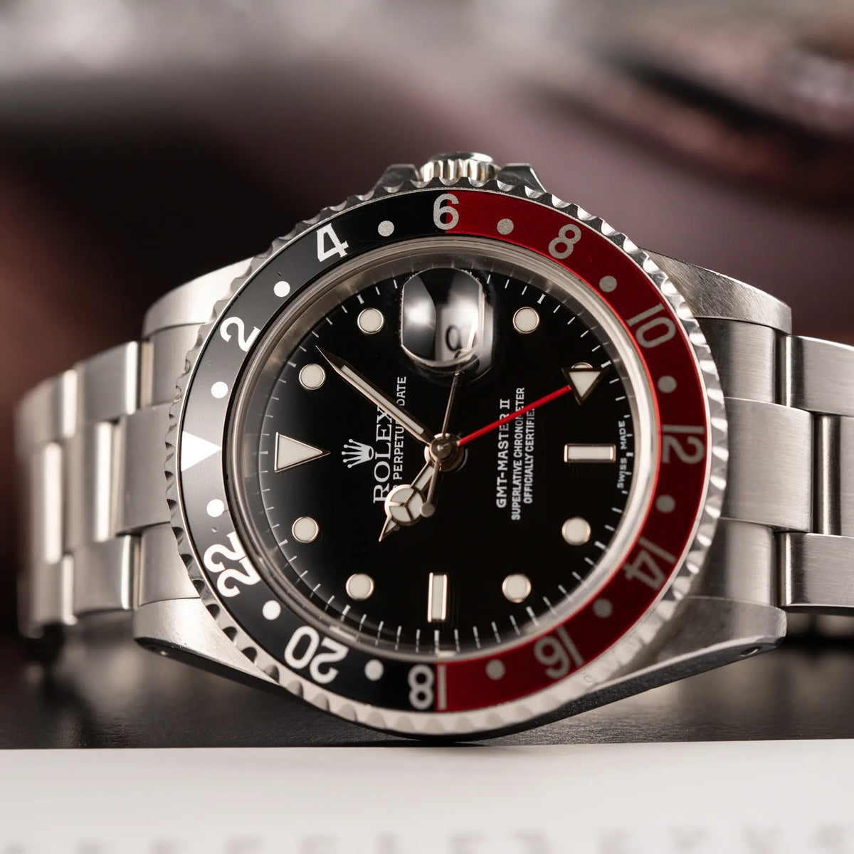 Detailaufnahme des Uhrenkopfes von der Rolex GMT-Master II 16710 in Edelstahl mit schwarz-roten "Coke" Lünetten-Inlay