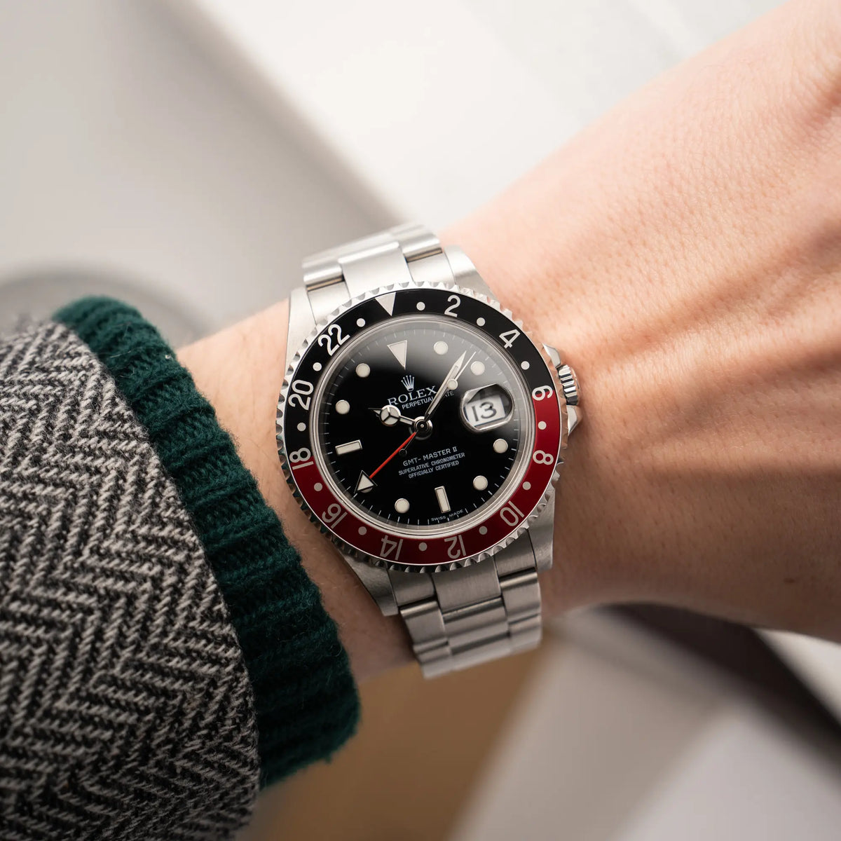 Mann trägt die Rolex GMT-Master II der Referenz 16710 mit der schwarz-roten "Coke"-Lünette aus 2007 mit dem "No-Hole"-Uhrengehäuse an seinem Handgelenk