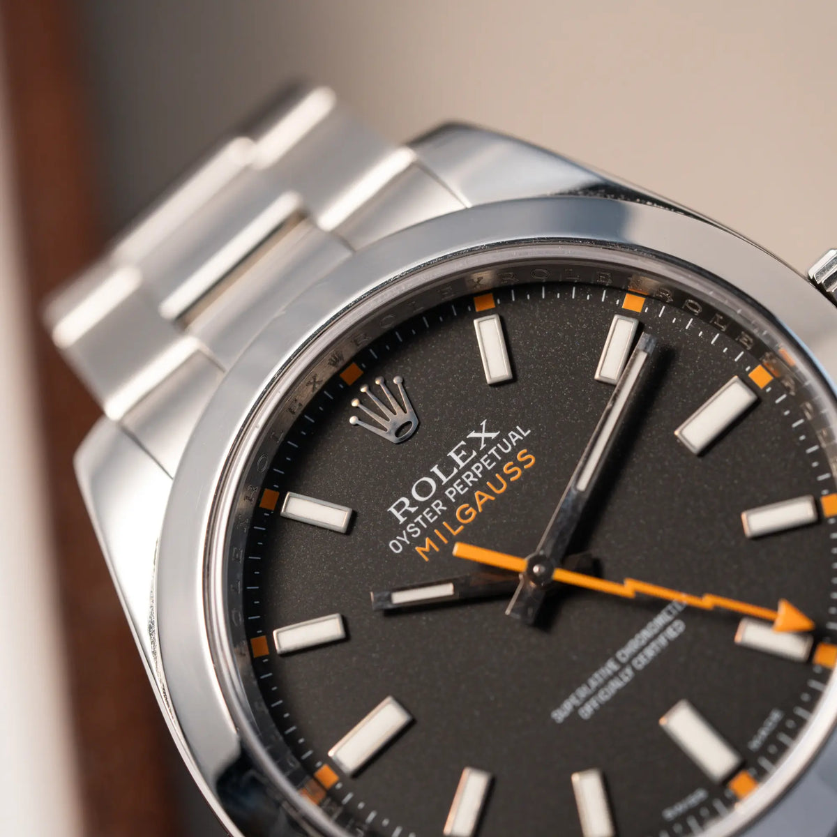 Detailaufnahme der Rolex Milgauss der Referenz 116400 mit schwarzem Zifferblatt und orangen Akzenten