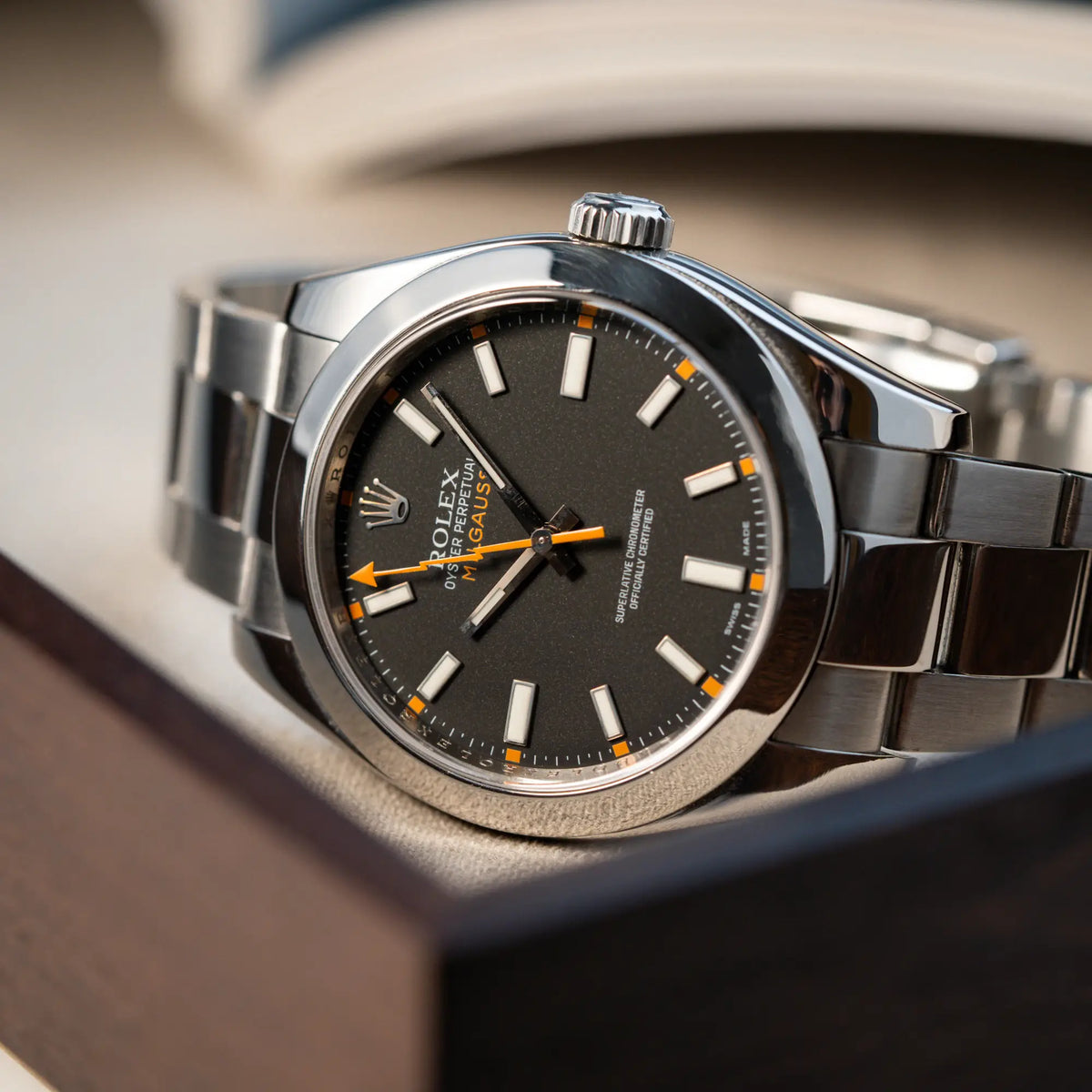 Fotografie der Rolex Milgauss der Referenz 116400 mit schwarzem Zifferblatt und orangen Akzenten