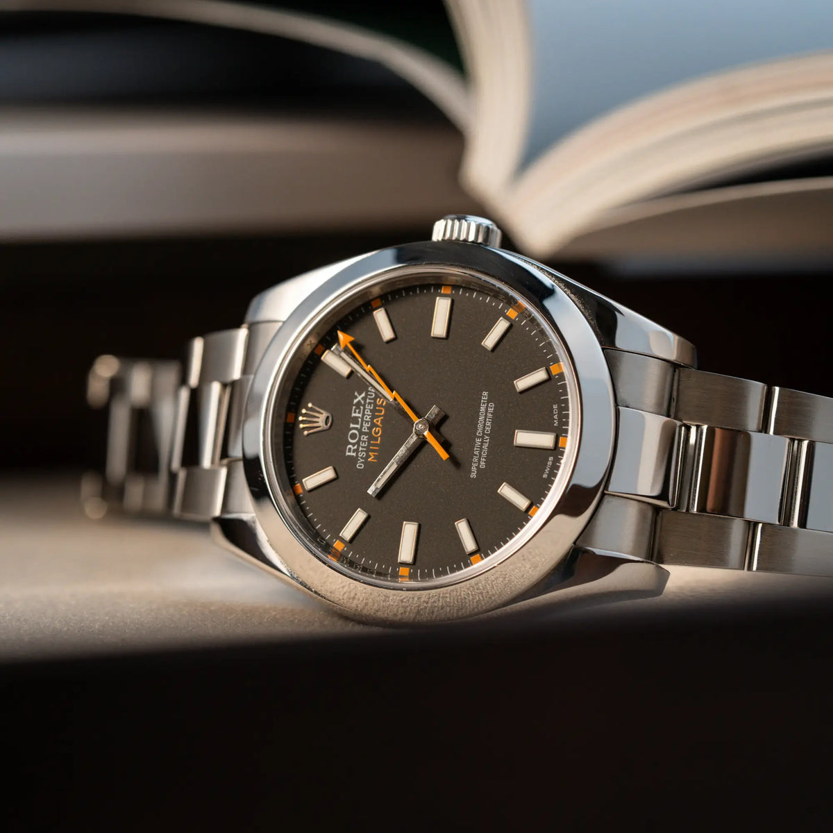 Titelbild der Rolex Milgauss der Referenz 116400 mit schwarzem Zifferblatt und orangen Akzenten