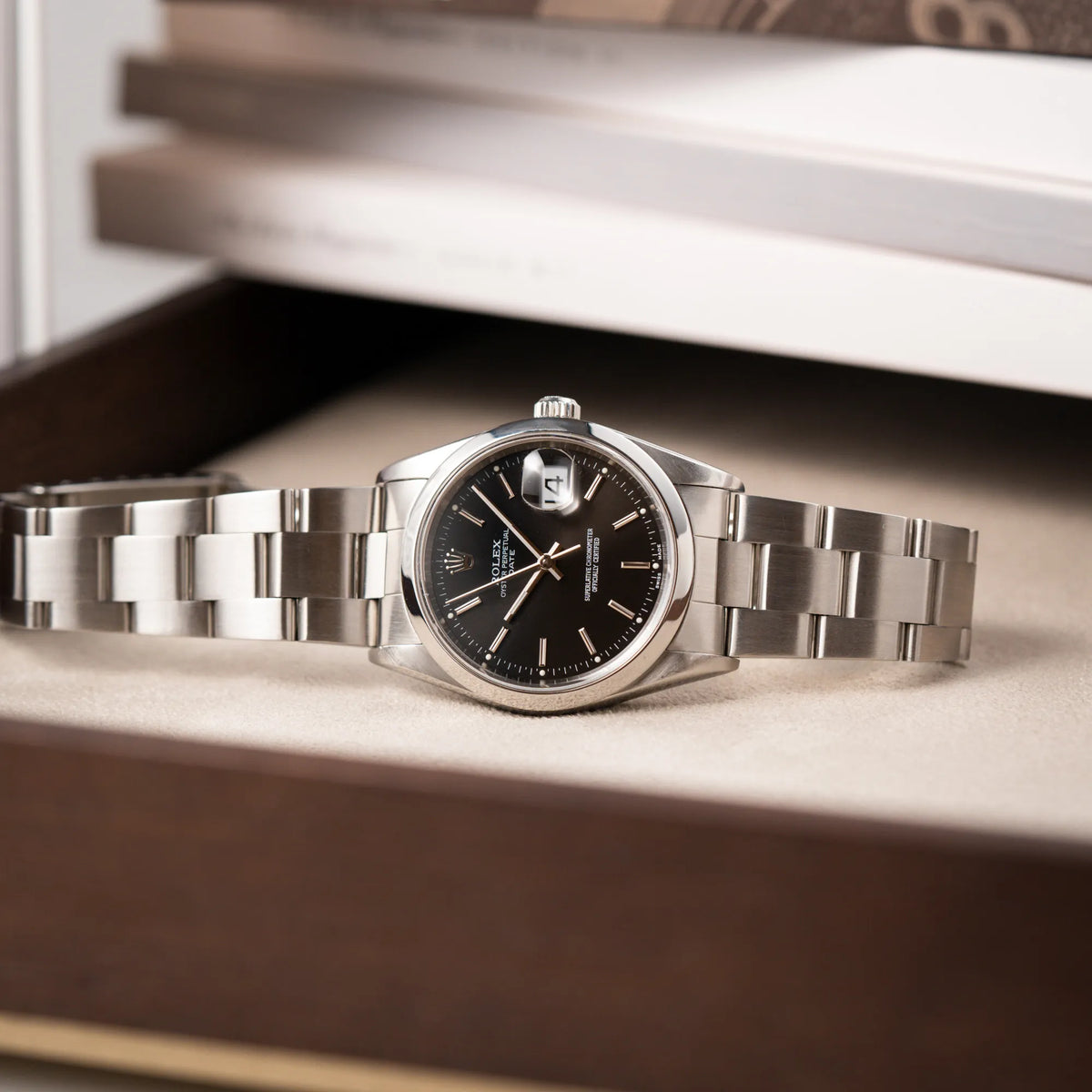 Produktfotografie der seitlich liegenden Rolex Oyster Perpetual 34 mit schwarzem Zifferblatt der Referenz 15200 mit glatter Lünette und 34mm Gehäusedurchmesser