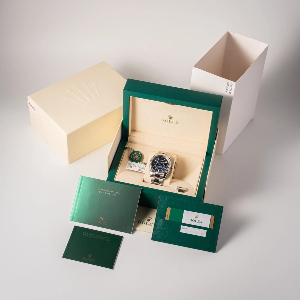 Lieferumfang zu der Jahreskalender Rolex Sky-Dweller der Referenz 326934 mit blauem Zifferblatt am Oyster-Stahlband, bestehend aus ox mit Umkarton, Booklets, hangtag und original Papieren
