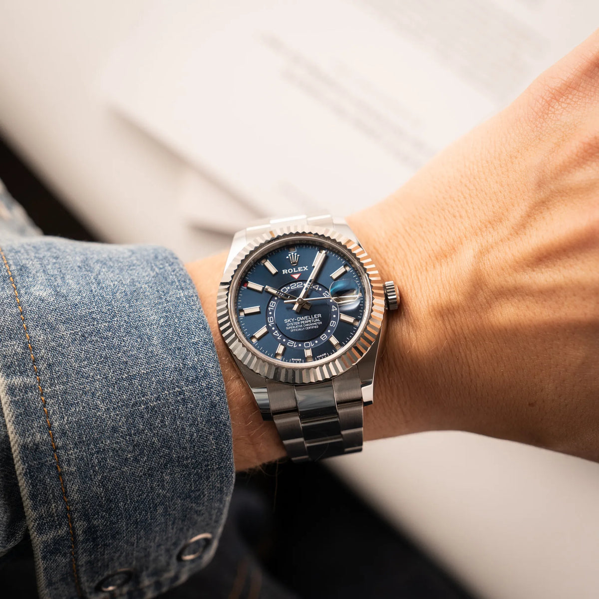 Mann trägt en Jahreskalender Rolex Sky-Dweller der Referenz 326934 mit blauem Zifferblatt am Oyster-Stahlband an seinem Handgelenk