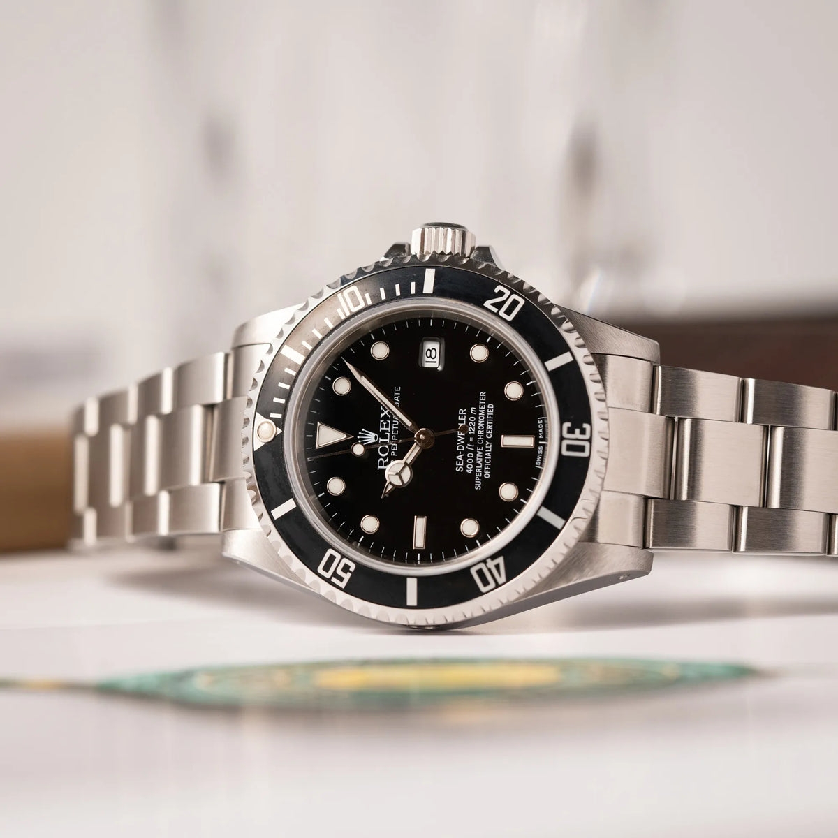 Rolex Sea-Dweller 4000 der Referenz 16600 mit schwarzem Blatt und schwarzer Aluminium-Lünette leigt seitlich auf der Gehäuseflanke
