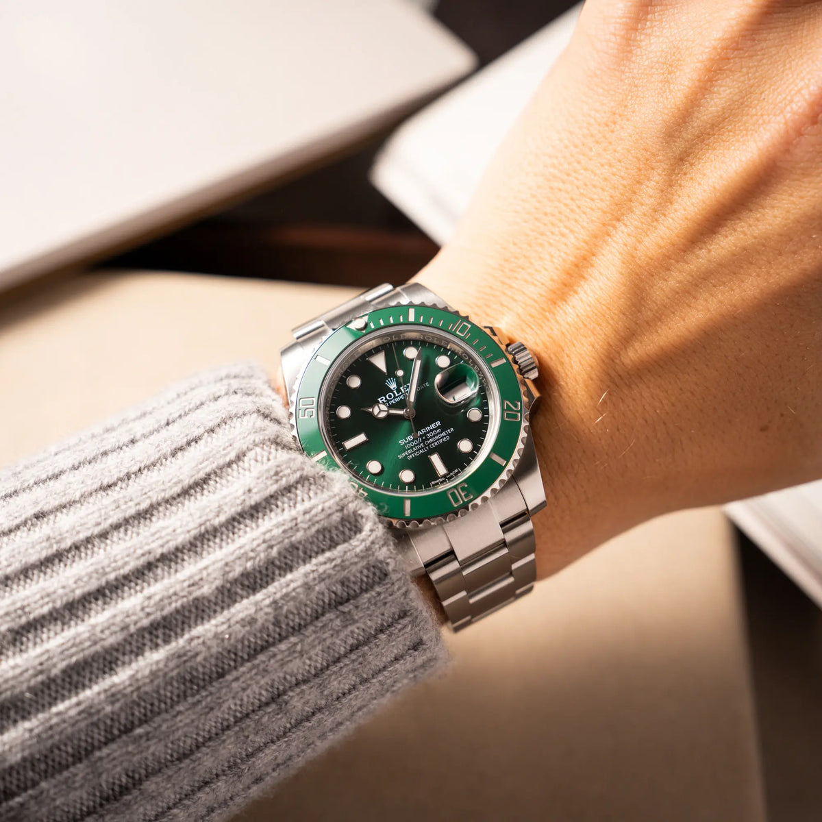 Mann trägt die Rolex Submariner Date 116610LV "Hulk" mit grünem Zifferblatt und grüner Keramik-Lünette an seinem Arm