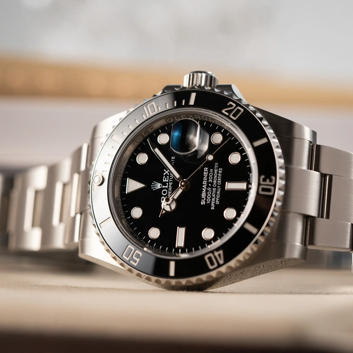 Detailaufnahme der seitlich auf dem Uhrengehäuse liegenden Rolex Submariner Date in schwarz mit Keramik-Lünette am Oyster-Stahlband aus 2023 mit dem 41mm-Oyster-Gehäuse