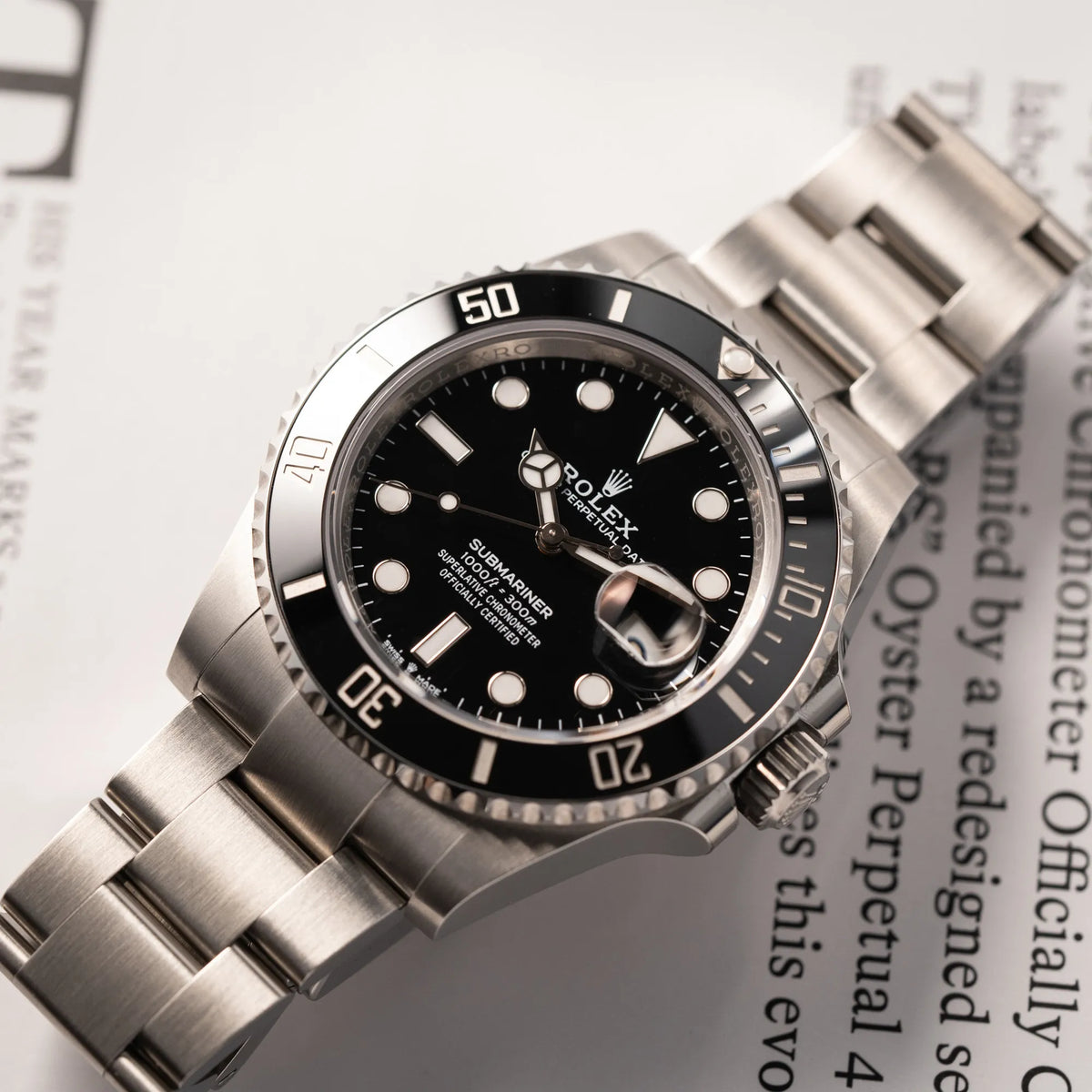 Produktfotografie der flach liegenden Rolex Submariner Date 126610LN am Oyster-Stahlband im Neuzustand aus 2024