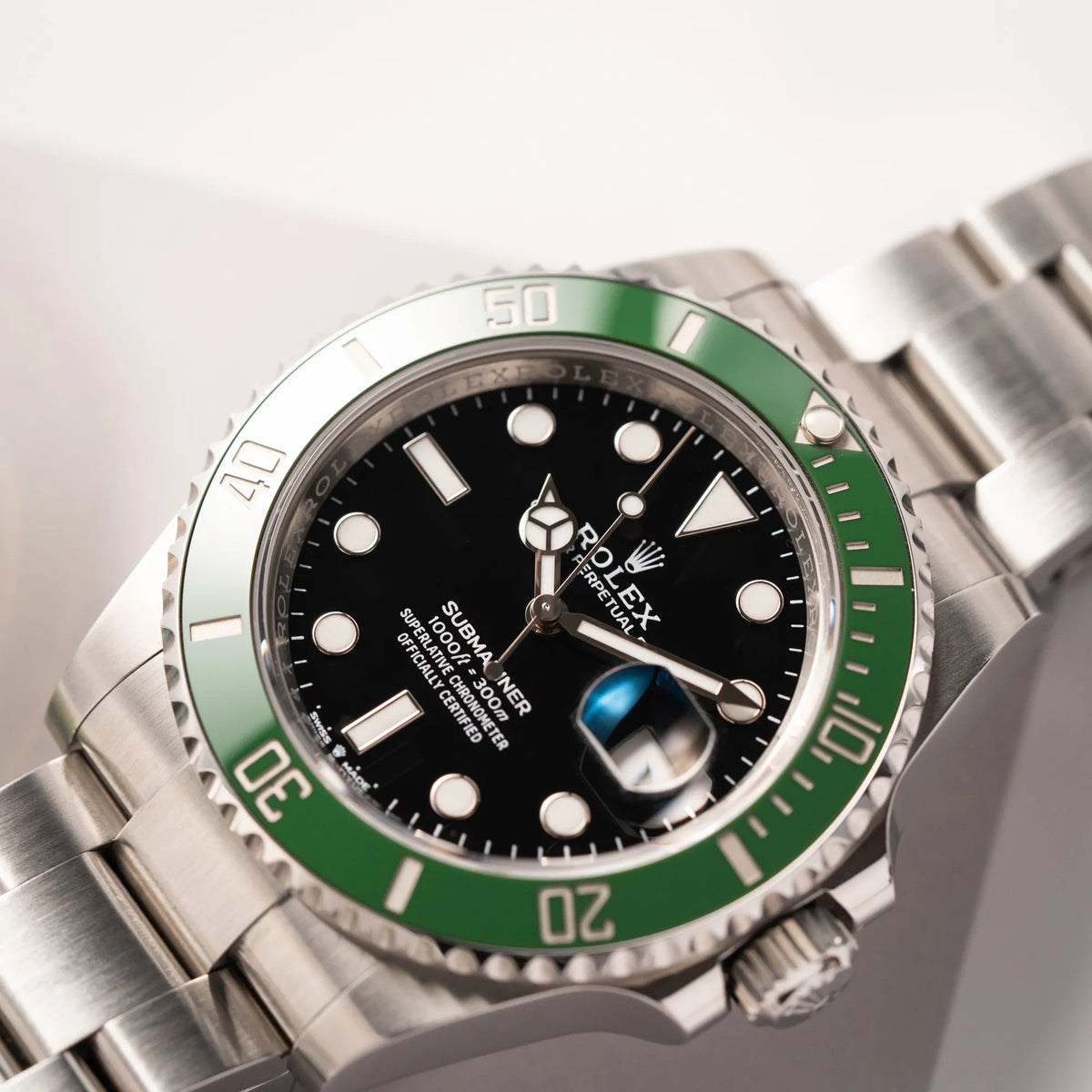 Produktfotografie zeigt den Uhrenkopf der Rolex Submariner Date 126610LV, Nickname "Starbucks", mit schwarzem Zifferblatt und grüner Keramik-Lünette in der MK2-Ausführung am Oyster-Stahl-Band