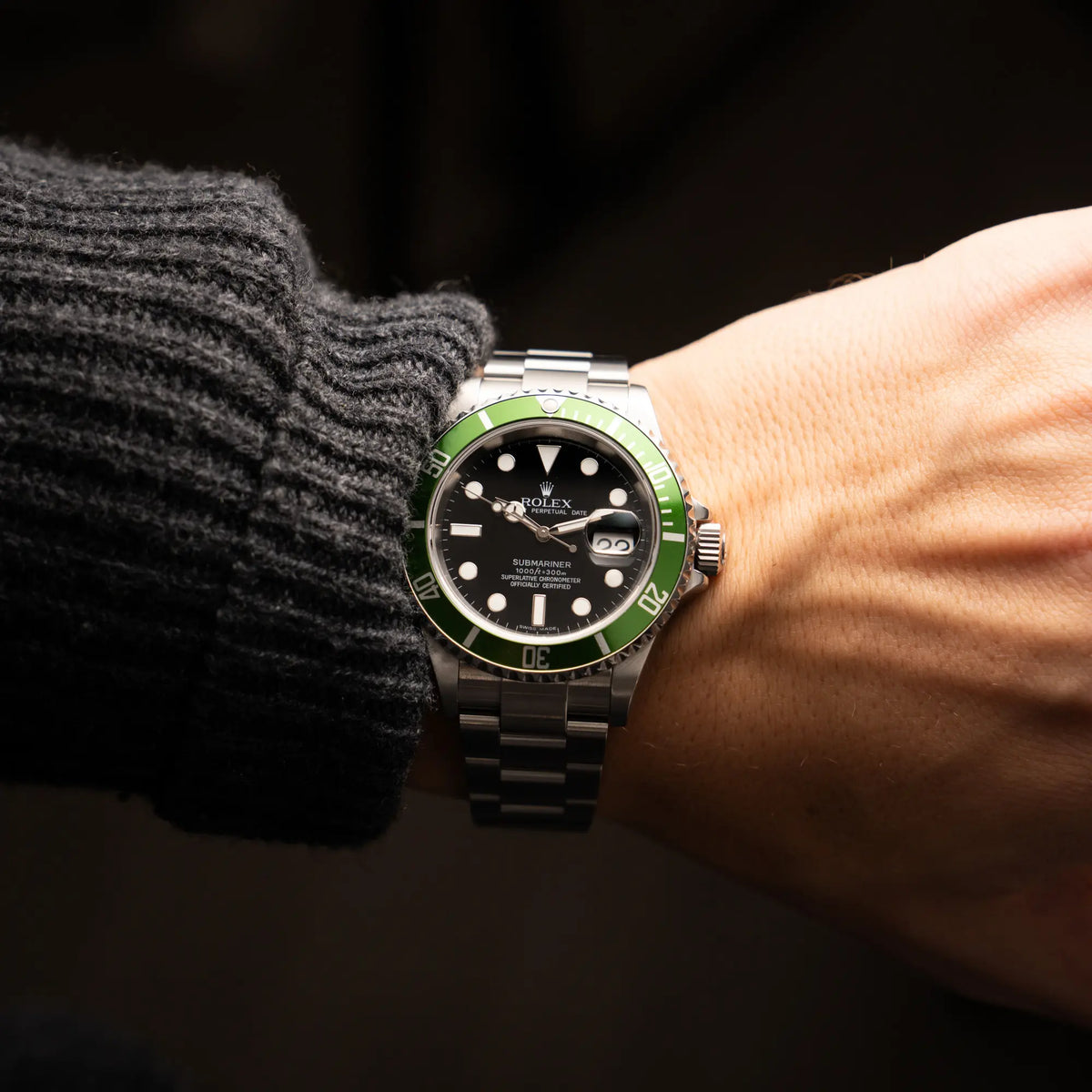 Mann trägt die Rolex Submariner Date 16610LV aus 2007 mit schwarzem Zifferblatt und der grünen "Kermit" Aluminium-Lünetten-Einlage für einen Wristshot an seinem Handgelenk
