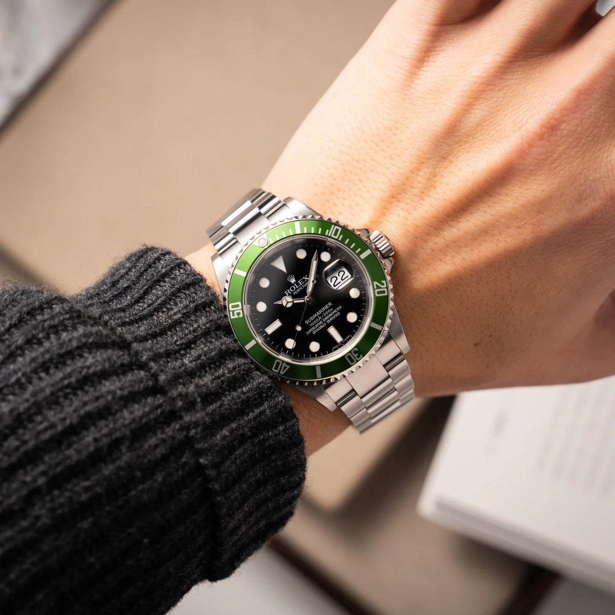 Mann trägt die Rolex Submariner Date 16610LV aus 2007 mit schwarzem Zifferblatt und der grünen "Kermit" Aluminium-Lünetten-Einlage an seinem Handgelenk