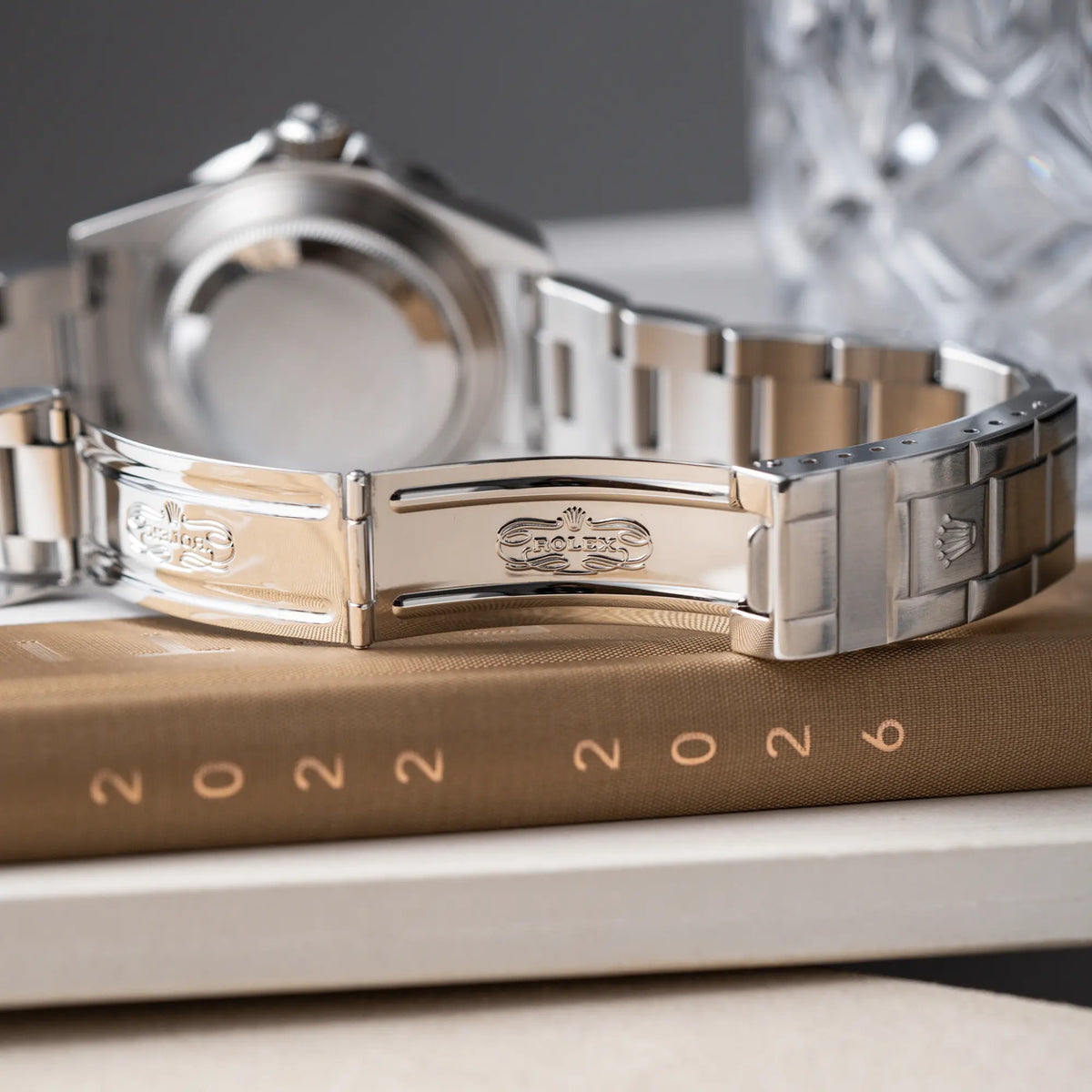 Produktfotografie der Rolex Submariner Date 16610LV aus 2007 mit schwarzem Zifferblatt und der grünen "Kermit" Aluminium-Lünetten-Einlage zeigt das klassische Rolex Logo im Inneren der Faltschliesse