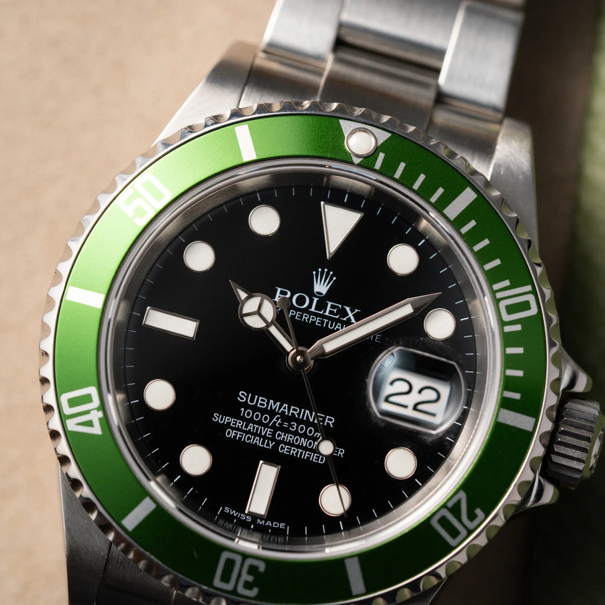 Detailaufnahme der Rolex Submariner Date 16610LV aus 2007 mit schwarzem Zifferblatt und der grünen "Kermit" Aluminium-Lünetten-Einlage