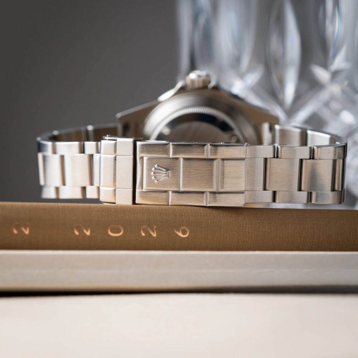Produktfotografie der Rolex Submariner Date 16610LV aus 2007 mit schwarzem Zifferblatt und der grünen "Kermit" Aluminium-Lünetten-Einlage zeigt den Zustand des Oyster-Stahlbands