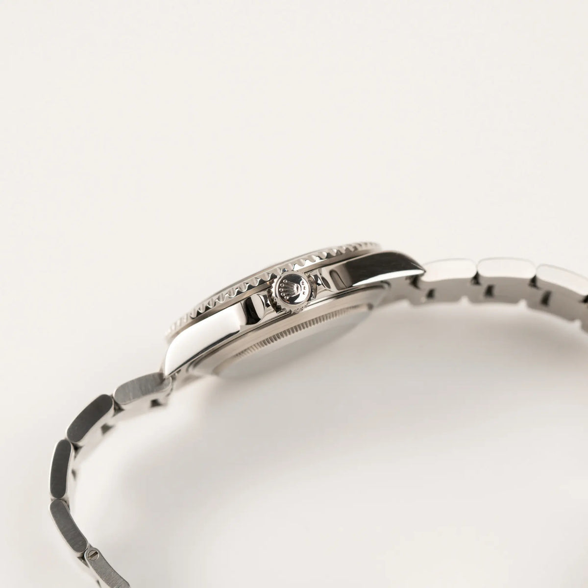 Seitliche Gehäuseflanke der Rolex Submariner Date 16610LV aus 2007 mit schwarzem Zifferblatt und der grünen "Kermit" Aluminium-Lünetten-Einlage mit Blick auf die Aufzugskrone