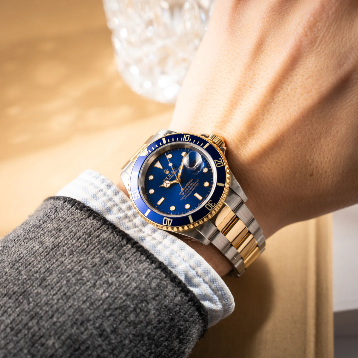 Mann trägt die bicolor Rolex Submariner Date der Referenz 16613 mit dem Spitznamen "Bluesy" in Stahl-Gold mit blauem Zifferblatt an seinem Handgelenk