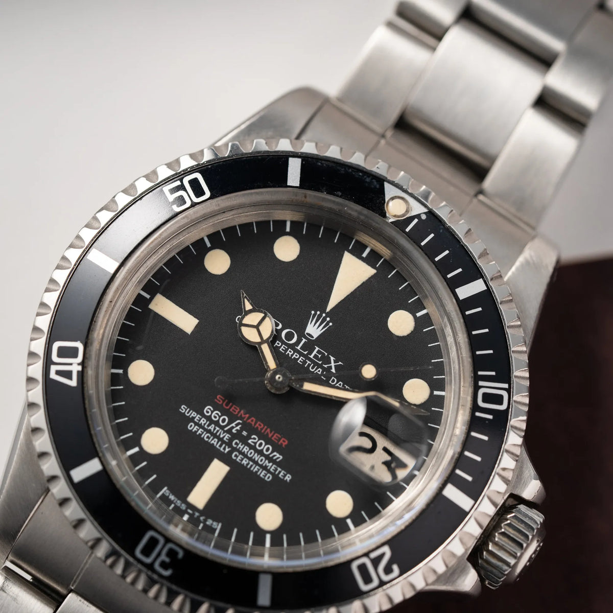 Nahaufnahme der Rolex Submariner Date 1680 mit dem Submariner Red Schriftzug auf dem Mark V Zifferblatt mit schöner gleichmäßiger Patina bei den Zeigern und Indizes