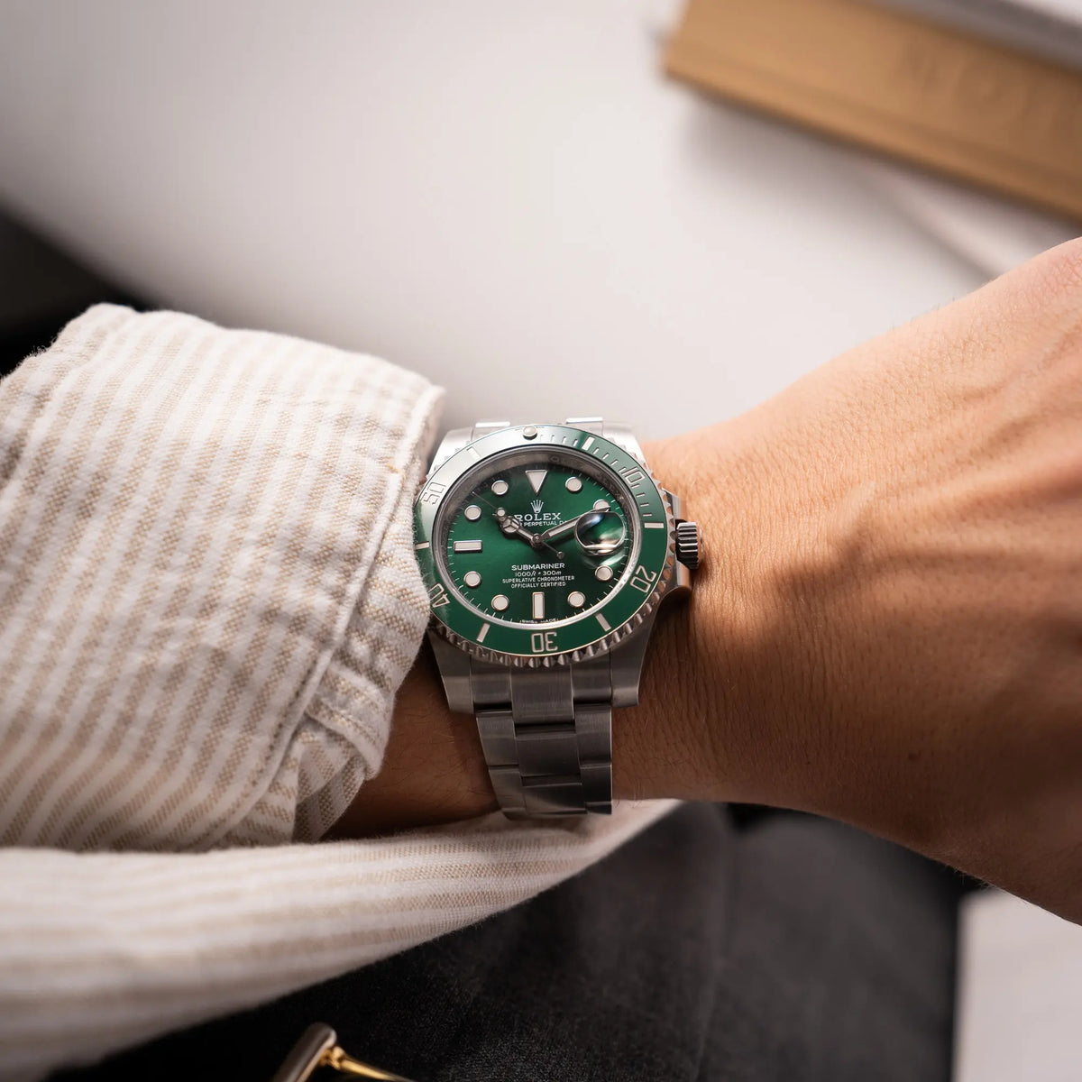 Wristshot mit der Rolex Submariner Date 116610LV, Nickname "HULK", mit dem grünen Zifferblatt und der grünen Keramik-Lünette, an dem klassischen Oyster-Stahl-Armband an einem Männerhandgelenk
