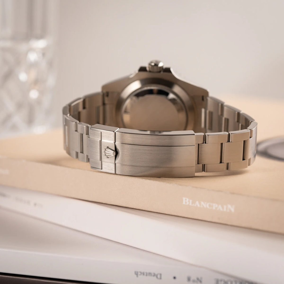 Prduktfotografie der Rolex Submariner Date Starbucks 126610LV mit schwarzem Zifferblatt und grüner Cerachrom-Lünette zeigt das Stahlband und die Faltschliesse