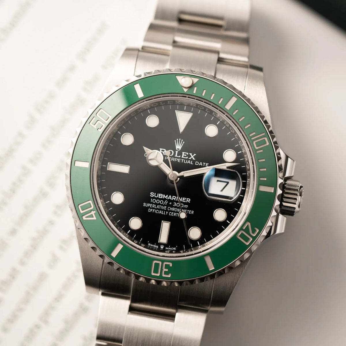Detailaufnahme der Rolex Submariner Date Starbucks der Referenz 126610LV im 41mm Oyster-Case mit der typischen grünen Keramik-Lünette