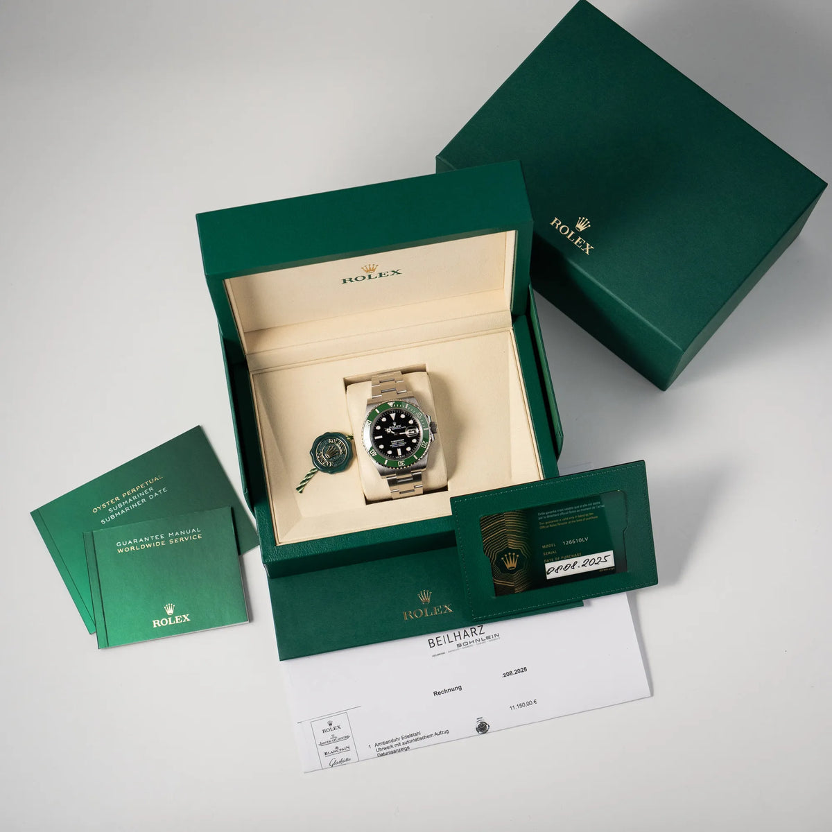 Lieferumfang zu der Rolex Submariner Date Starbucks 126610LV Mark 2 aus 2025 mit der typischen grünen Cerachrom-Lünette, bestehend aus Box mit Umkarton, Hangtag, Booklets, original Rolex-Garantiekarte und Erstkaufbeleg