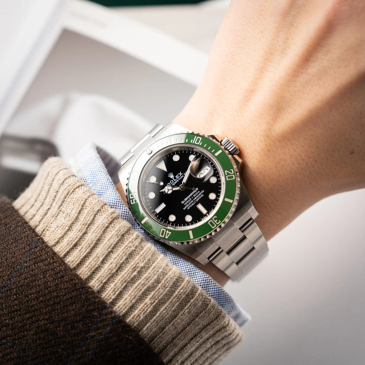 Mann trägt die Rolex Submariner Date Starbucks 126610LV Mark 2 aus 2025 mit der typischen grünen Cerachrom-Lünette an seinem Handgelenk
