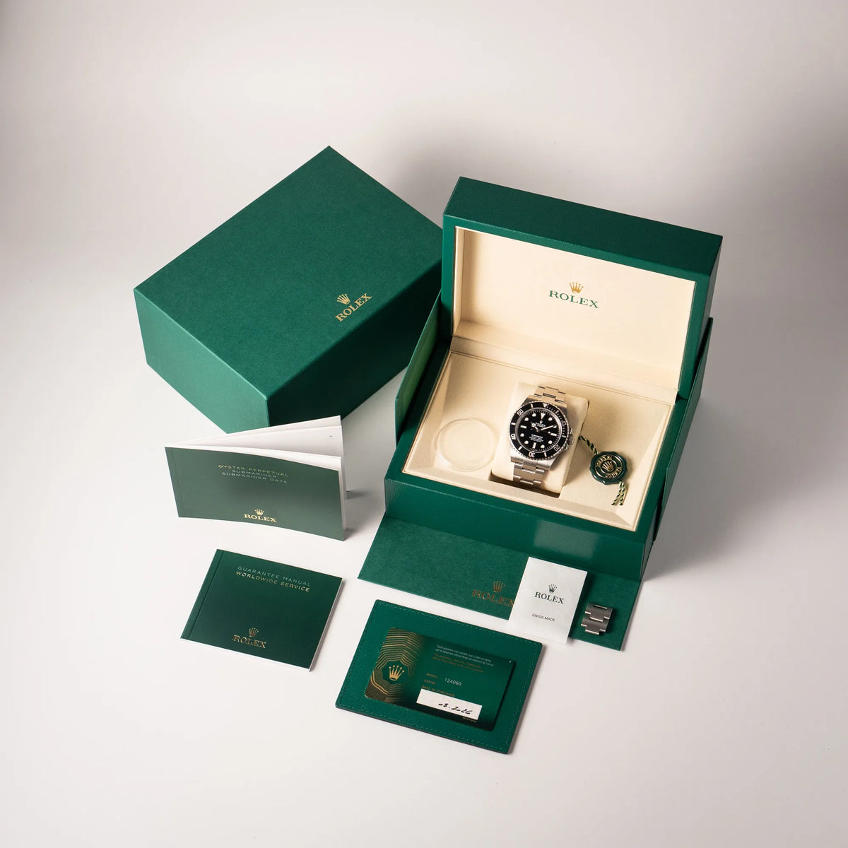 Lieferumfang zu der Rolex Submariner No Date der Referenz 124060 mit schwarzem Zifferblatt und schwarzer Keramik-Lünette an einem Oytser-Stahlband im Neuzustand, betsehend aus Box mit Umkarton, Booklets, Hangtag, Lünetten-Schutz und original Papieren mit Garantiekarte