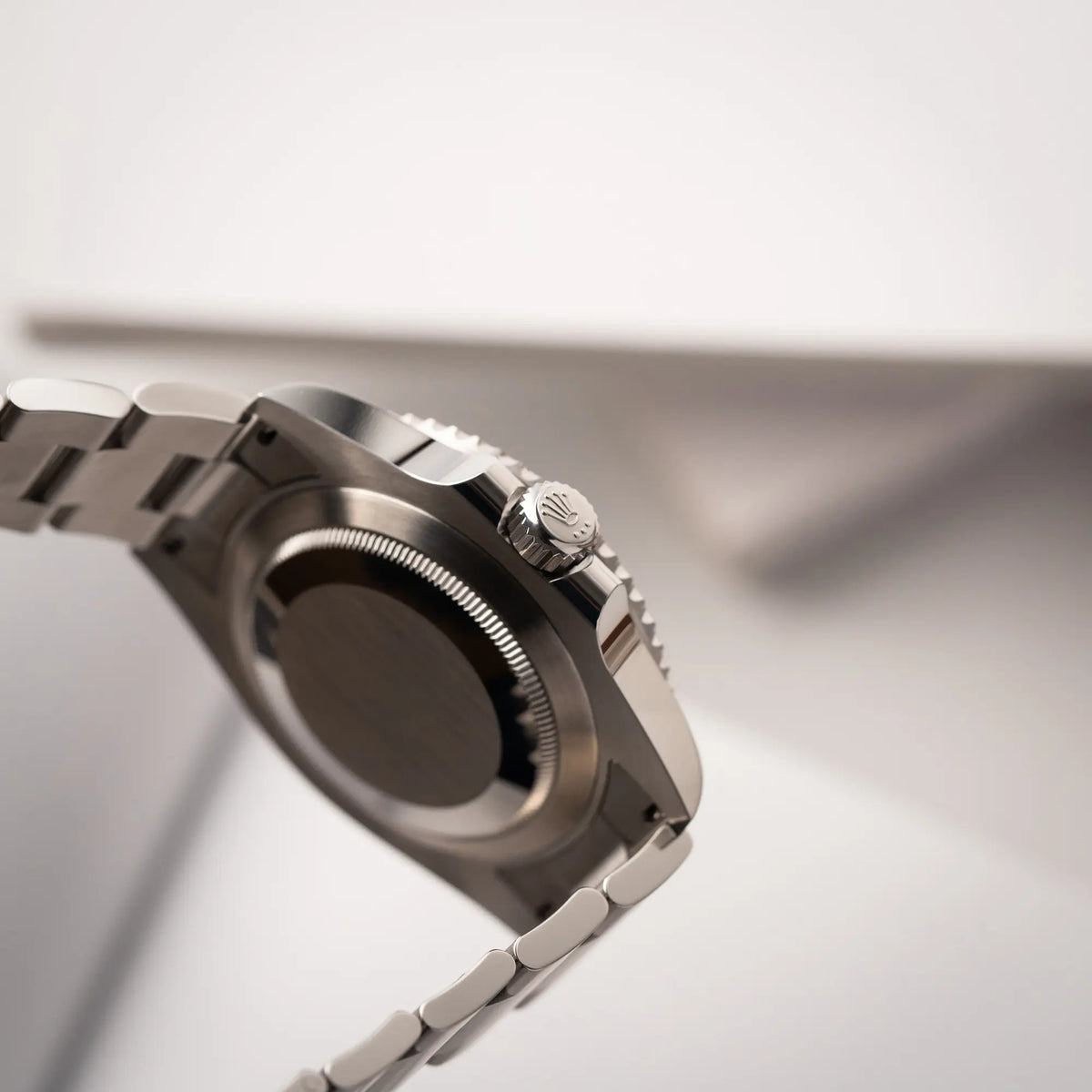 Produktfotografie der Rolex Submariner No Date der Referenz 124060 mit schwarzem Zifferblatt und schwarzer Keramik-Lünette an einem Oytser-Stahlband im Neuzustand zeigt die seitliche Gehäuseflanke mit Blick auf die Aufzugskrone