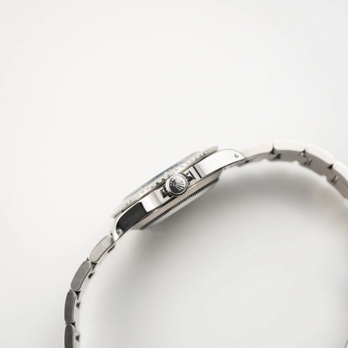 Seitliche Gehäuseflanke der Rolex Submariner No Date 14060M mit schwarzem Zifferblatt und der klassischen schwarzen Aluminium-Lünette zeigt die Aufzugskrone