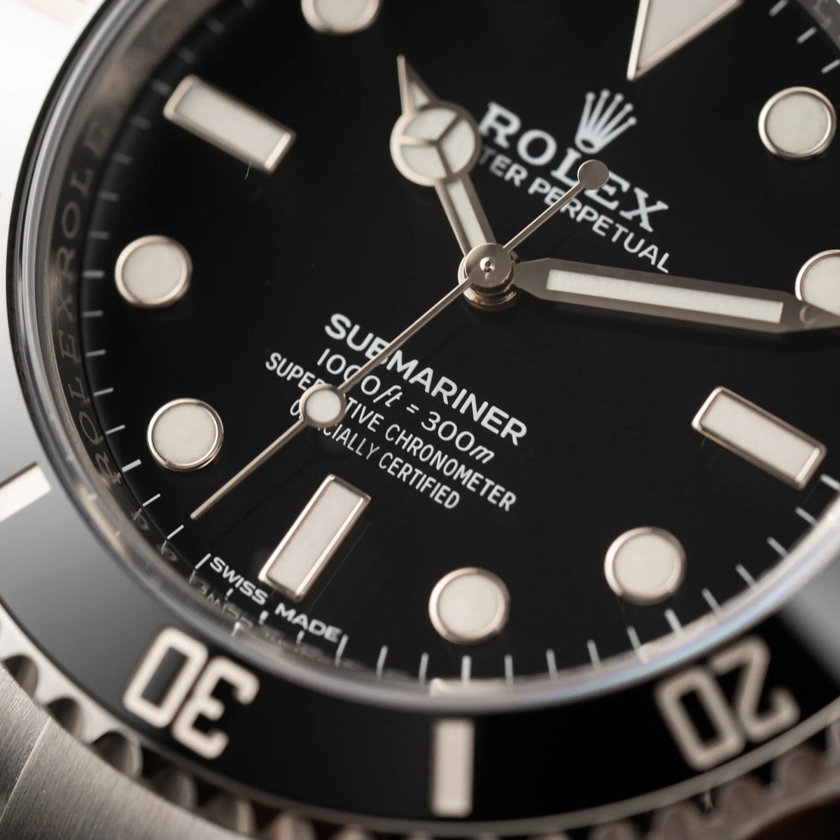 Detailaufnahme des "Submariner"-Schriftzugs auf dem Zifferblatt der Rolex Submariner 114060 No Date aus 2019 in der klassischen schwarzen Ausführung im Neuzustand