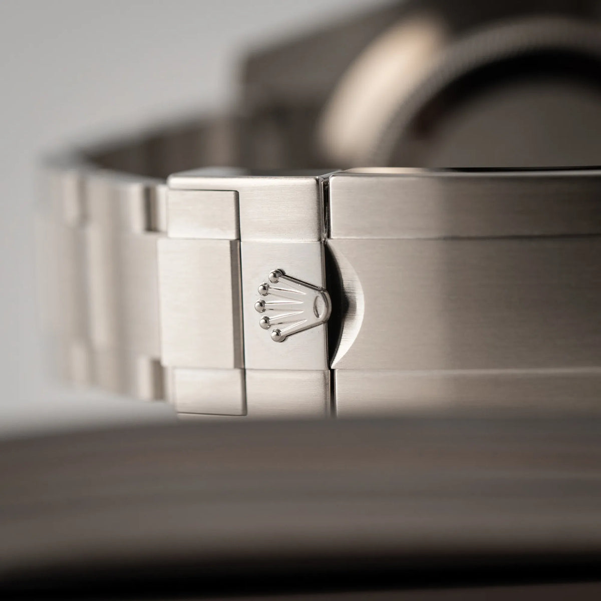 Detailaufnahme der Rolex-Krone auf der Oyster-Stahl-Faltschliesse der Rolex Submariner 114060 No Date aus 2019 in der klassischen schwarzen Ausführung im Neuzustand