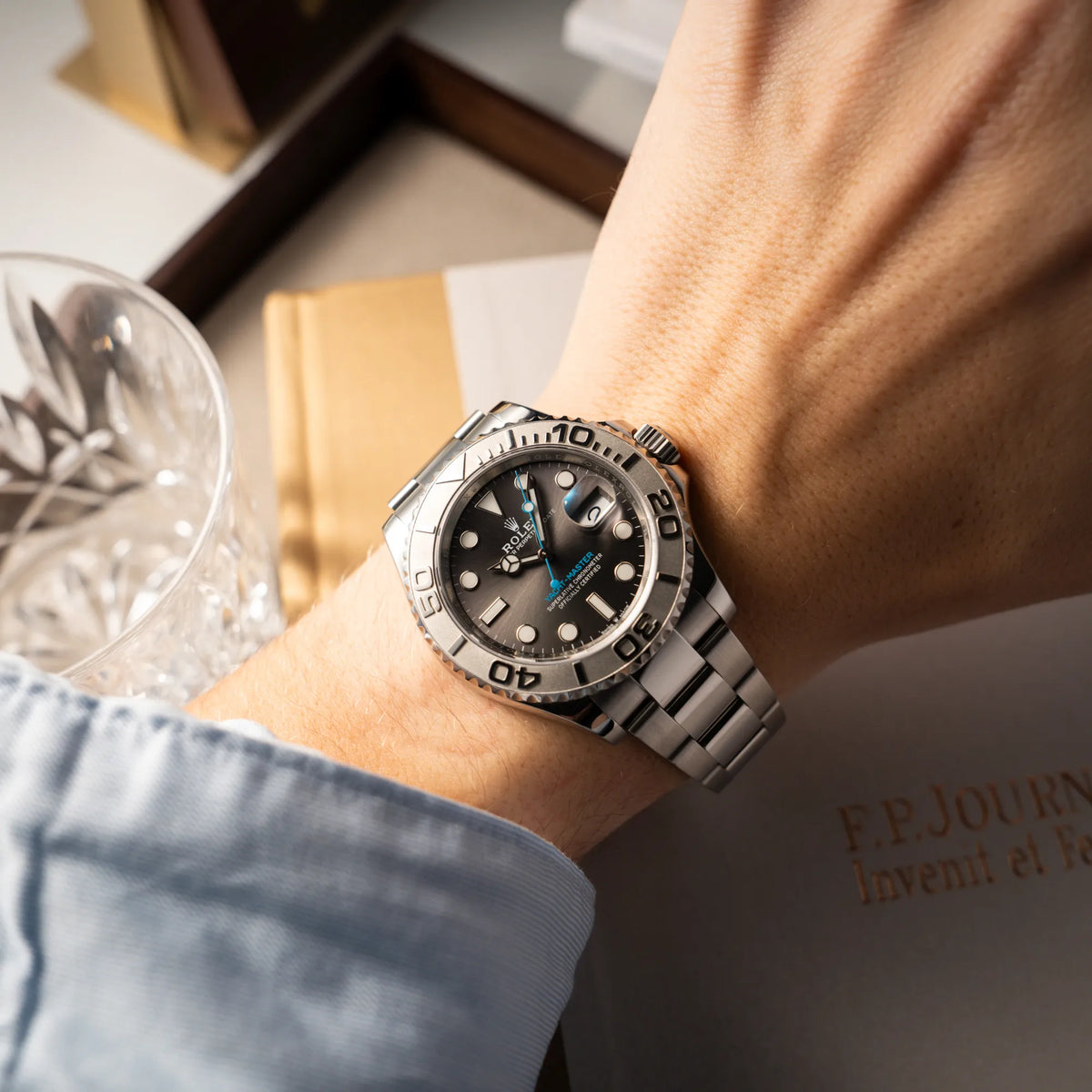 Mann trägt die Rolex Yachtmaster 40 mit Platin-Lünette der Referenz 126622 mit dem Rhodium-Zifferblatt und hellblauem Sekundenzeiger an seinem Handgelenk