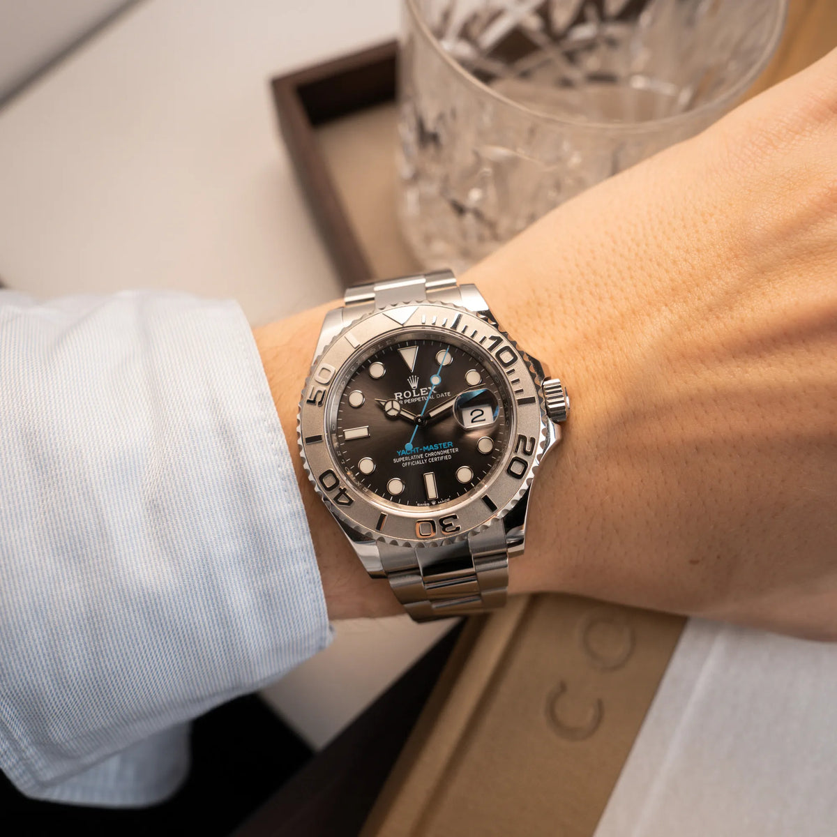 Mann in hellblauem Hemd mit der der Rolex Yachtmaster 40 mit Platin-Lünette der Referenz 126622 mit dem Rhodium-Zifferblatt und hellblauem Sekundenzeiger am Handgelenk