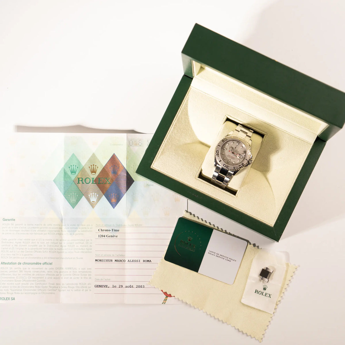 Lieferumfang zu der Rolex Yachtmaster 40 Platinum mit der Referenz 16622 mit Platin-Lünette und dem typischen roten Sekundenzeiger, betsehend aus Box, Poliertuch, Papieren und originaler Rolex-Service-Karte aus 2024