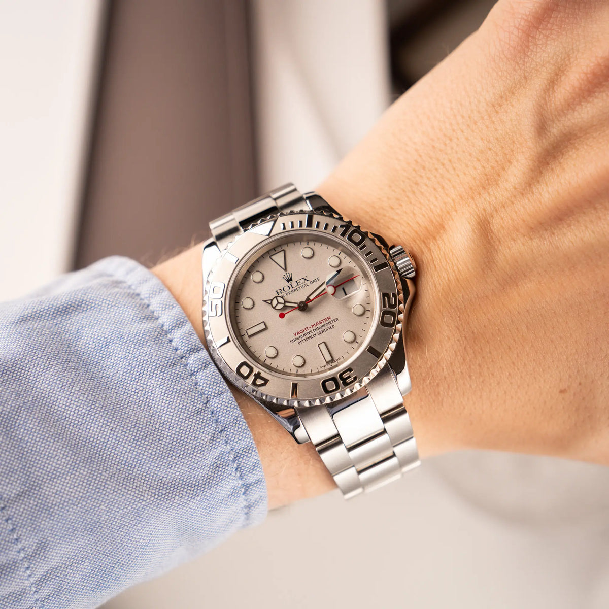Mann trägt die Rolex Yachtmaster 40 Platinum mit der Referenz 16622 mit Platin-Lünette und dem typischen roten Sekundenzeiger an seinem Handgelenk