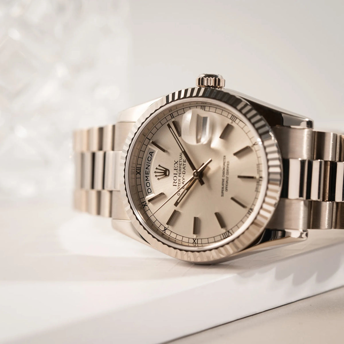 Produktfotografie mit Fokus auf dem Uhrenkopf der Rolex Day-Date 36 der Referenz 118239 in 750er Weißgold gefertigt mit dem klassischen President-Armband