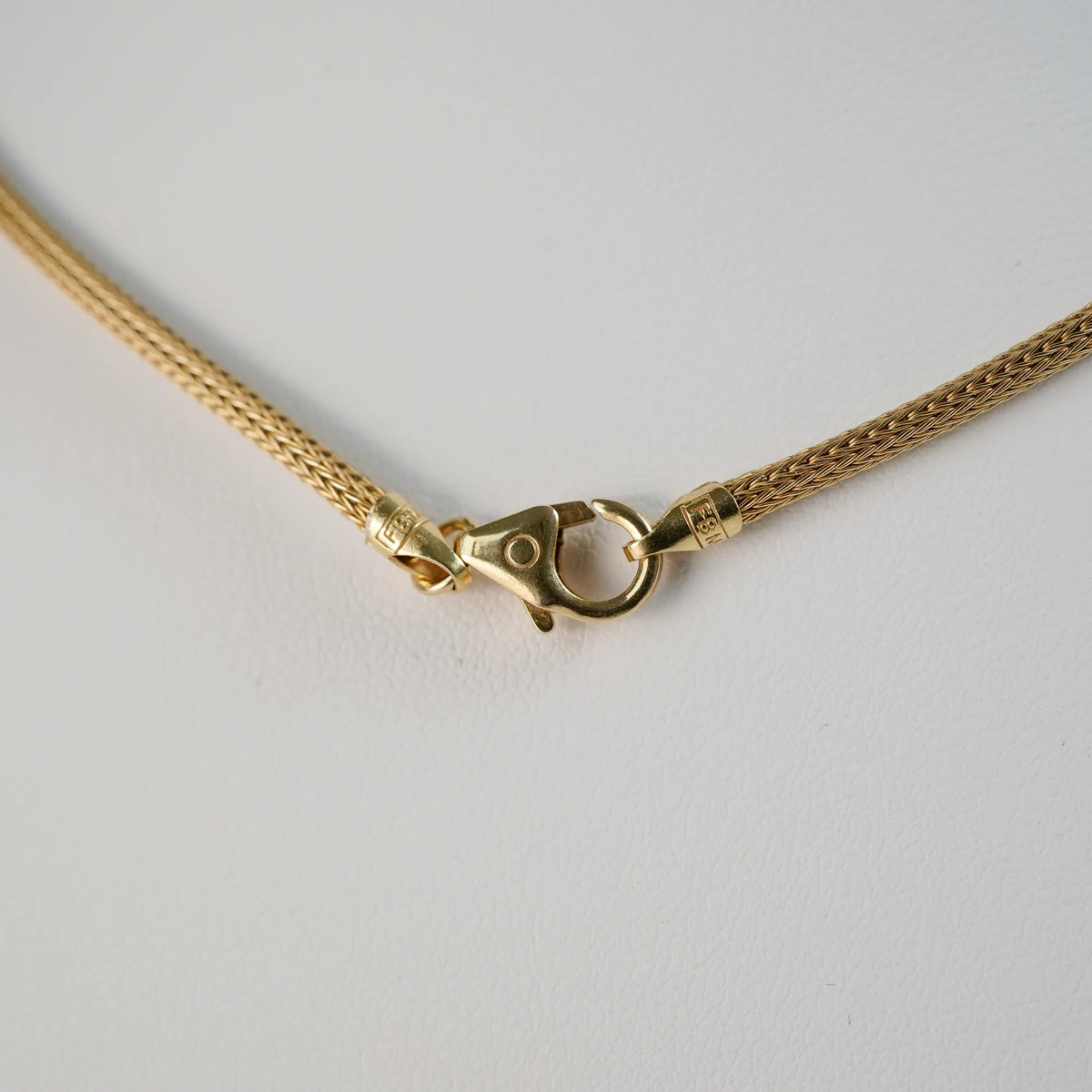 Detailaufnahme des gelbgoldenen Verschlussmechanismus mit einem Karabinerhaken