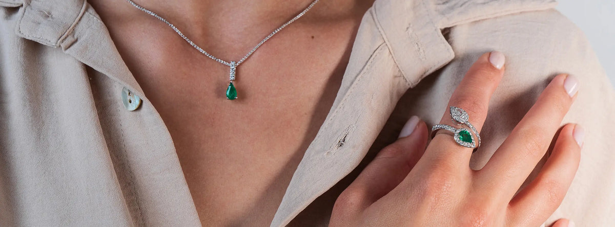 Startseite Bannerbild zeigt eine Dame die Smaragd-Weißgold-Schmuck mit Diamant trägt
