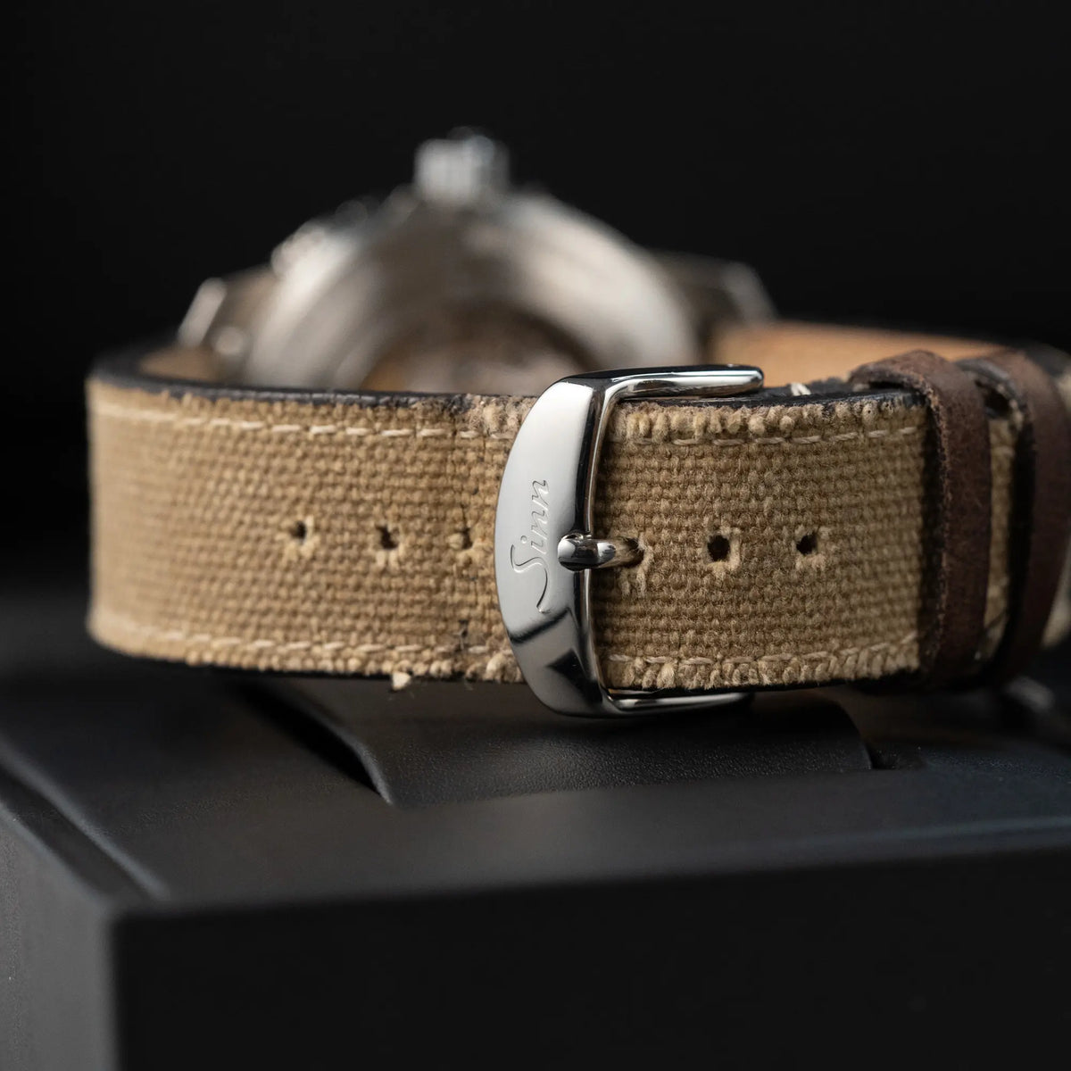 Produktfotografie der der Taucheruhr Sinn Automatik SA in Blau mit beigen Akzenten am Textilband mit Fokus auf der Sinn-Dornschliesse