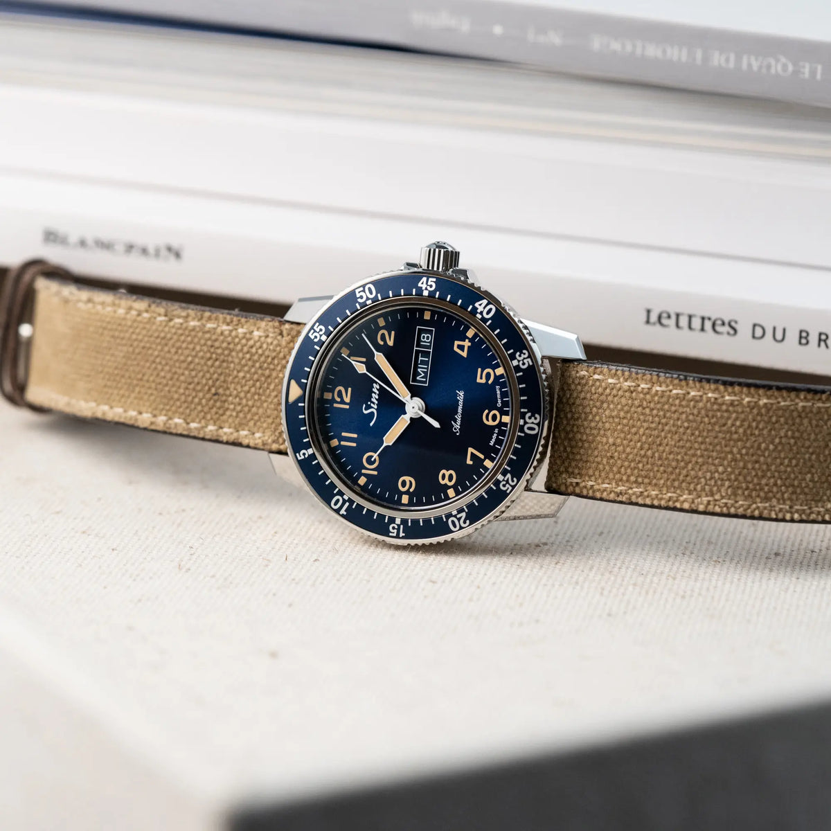 Produktfotografie der Taucheruhr Sinn Automatik SA in Blau mit beigen Akzenten am Textilband