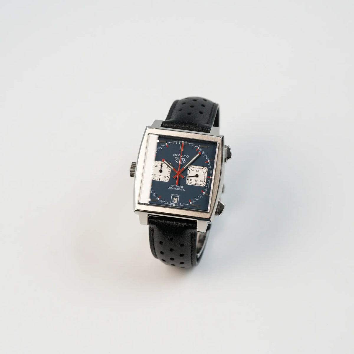 Leicht schräge Ansicht des Tag Heuer Monaco Calibre 11 Chronographen CAW211P mit dem klassischen blauen Zifferblatt und roten Details auf Ziegern und Indizes