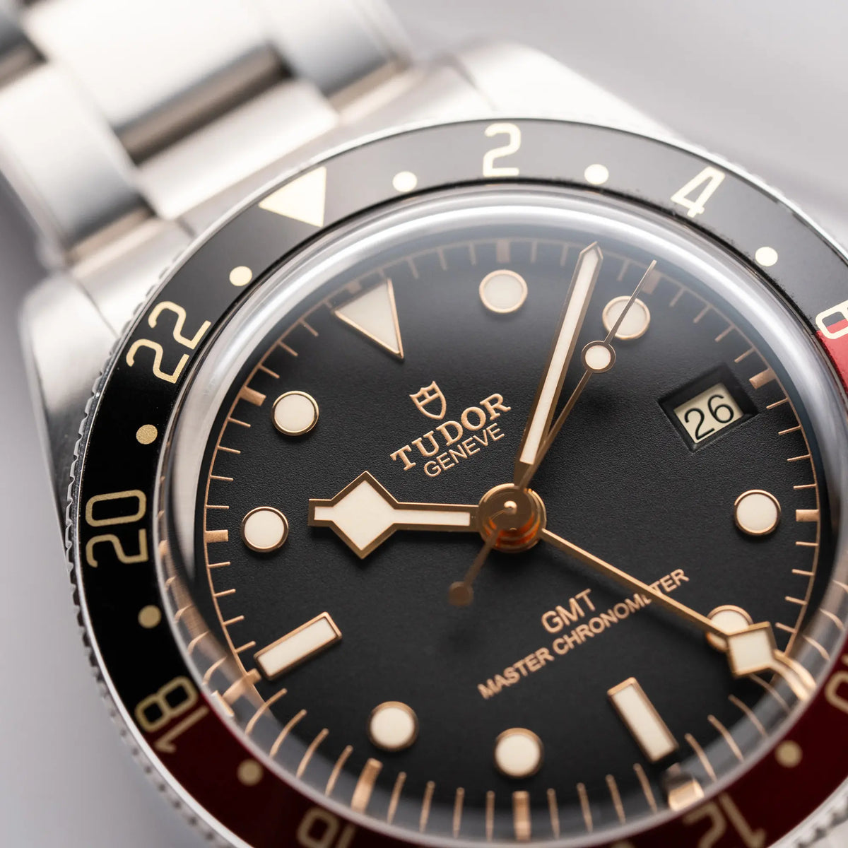 Detailaufnahme der Tudor BlackBay GMT Coke der Referenz 7939G1A0NRU mit der schwarz-roten Lünette und bronzefarbenen Details am Edelstahlarmband