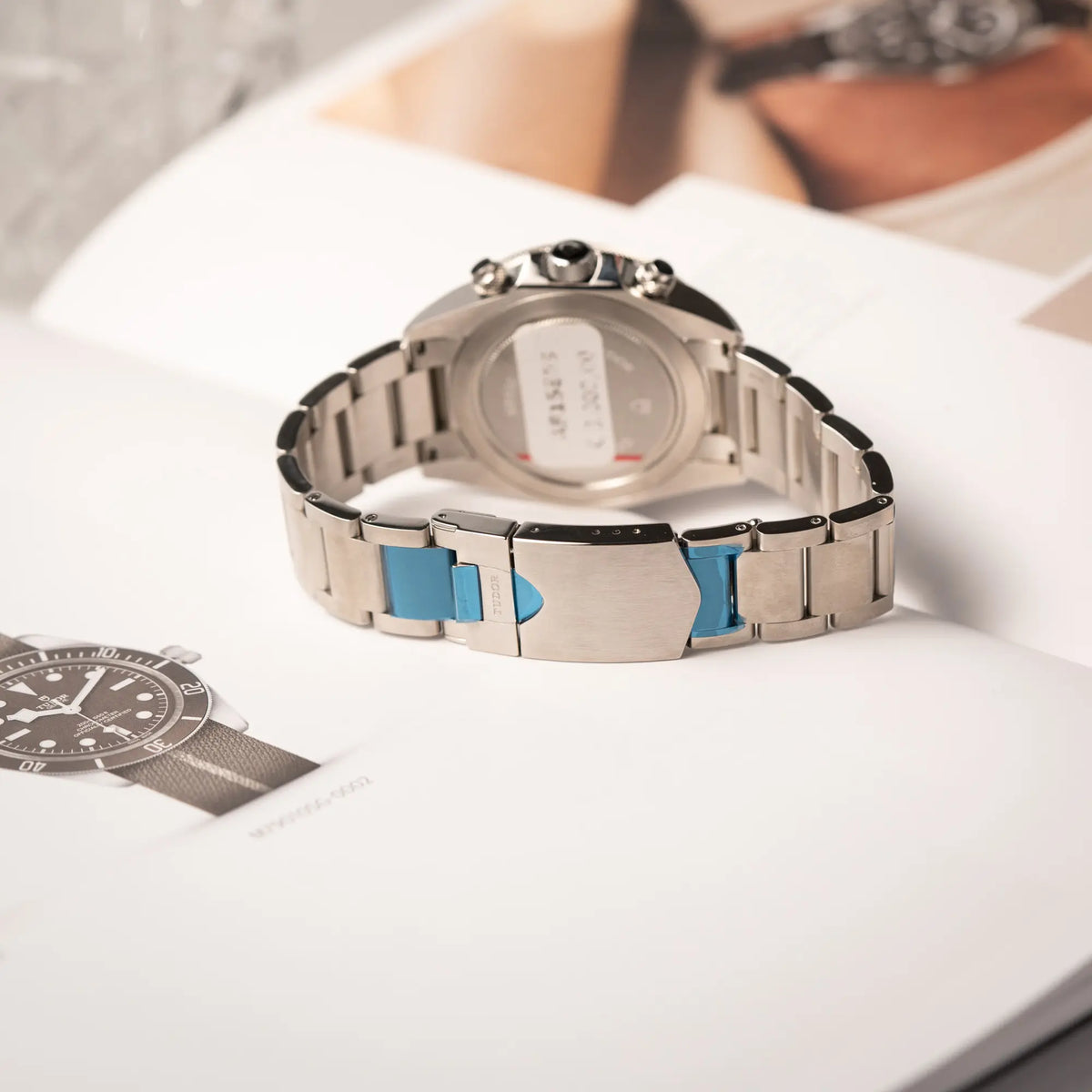 Produktfotografie zeigt die verklebte Schliesse von dem Tudor Black Bay Heritage Chronograph der Referenz 70330N mit schwarzem Zifferblatt und orangen Details