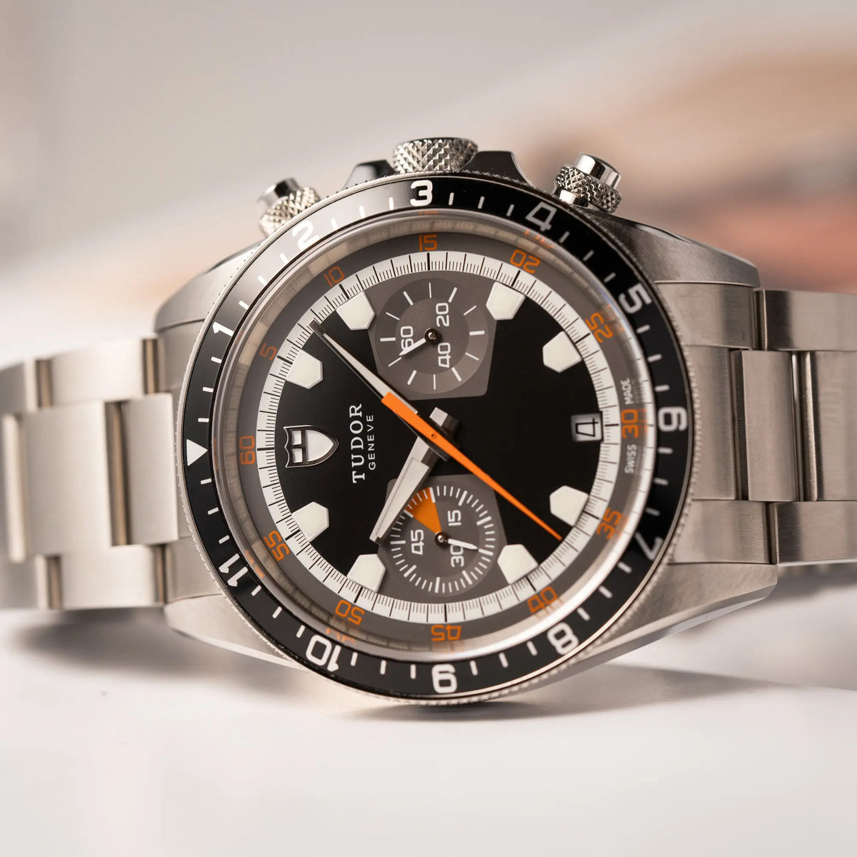 Detailaufnahme es Tudor Black Bay Heritage Chronographs der Referenz 70330N mit schwarzem Zifferblatt und orangen Details