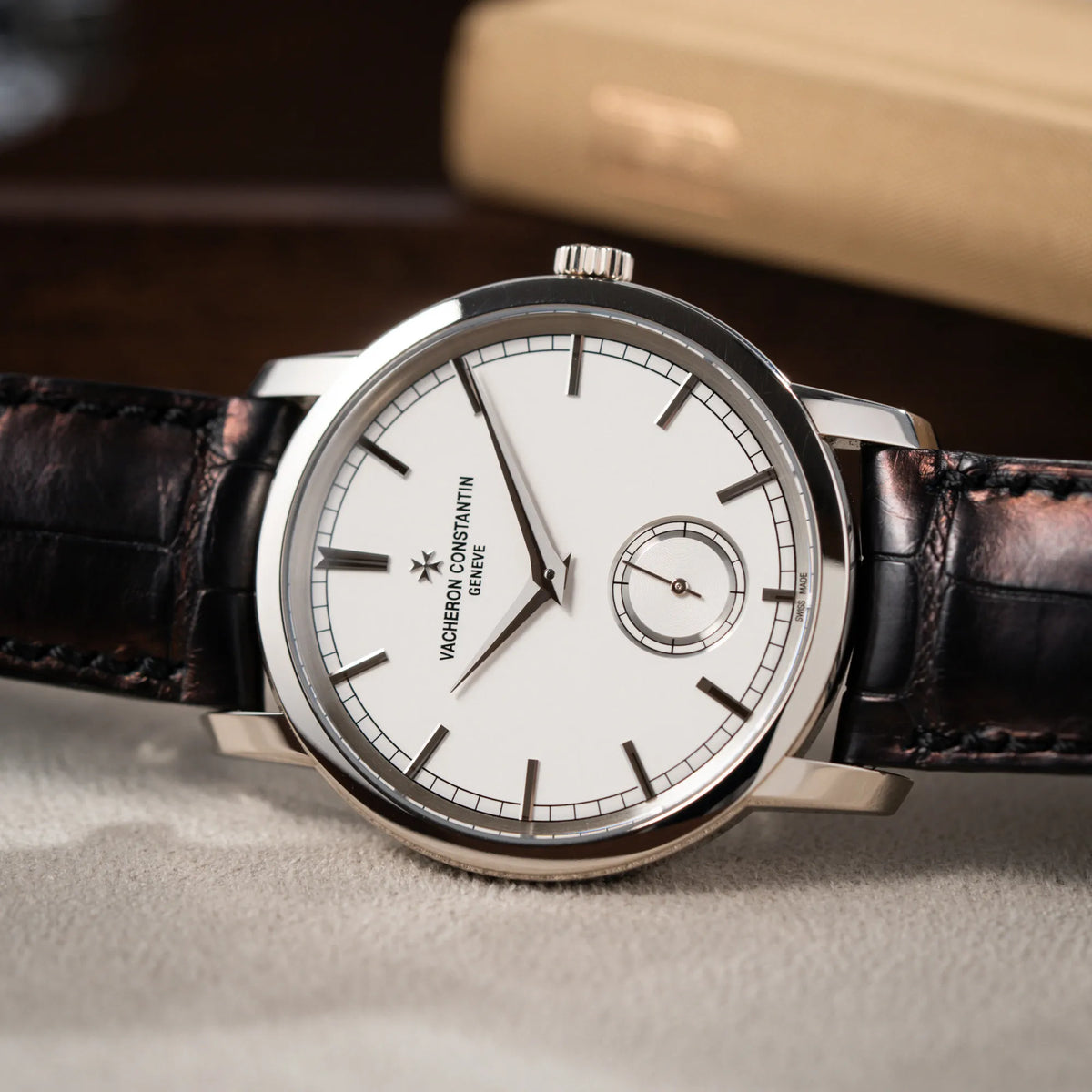 Detailaufnahme der seitlich auf dem Uhrengehäuse liegenden Vacheron Constantin Traditionelle 82172 mit weißem Zifferblatt und einem Weißgold-Gehäuse am braunem Lederband