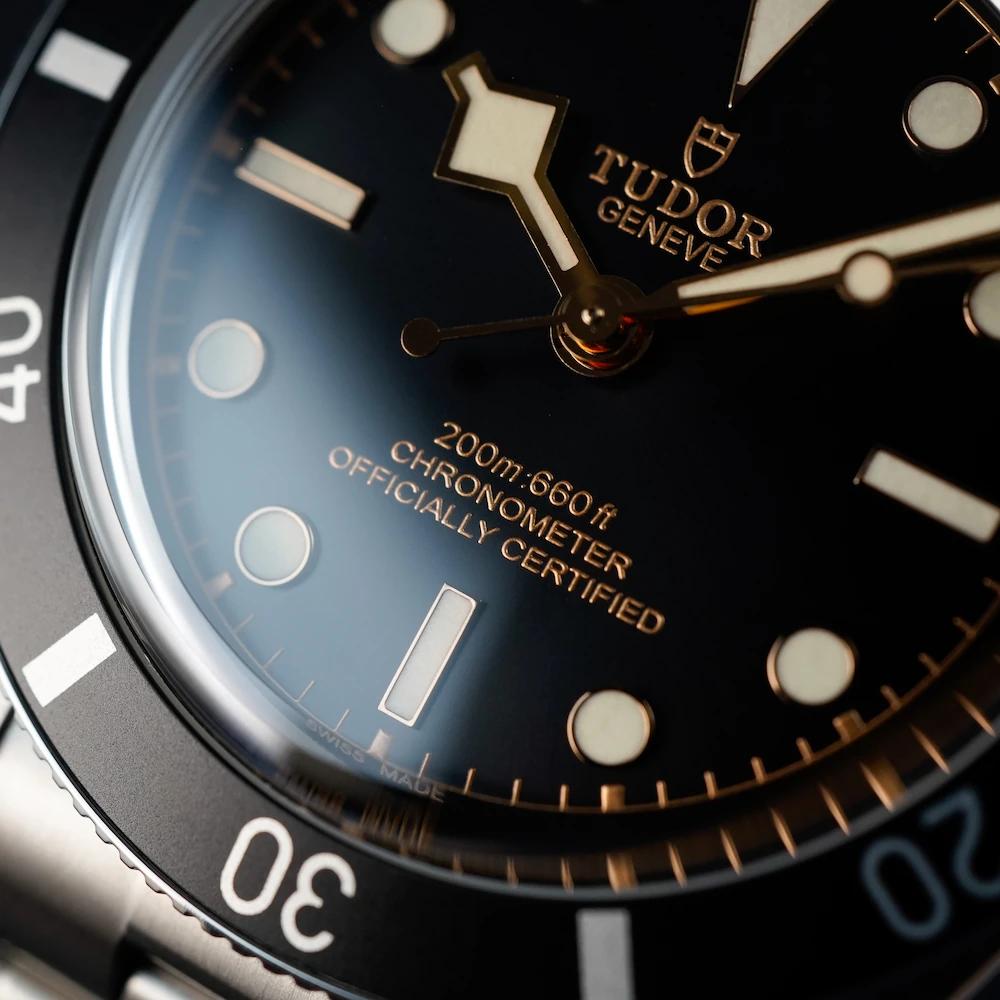 Makro-Aufnahme des Zifferblatts einer Tudor Black Bay 54 mit schwarzen und bronzenen Elementen