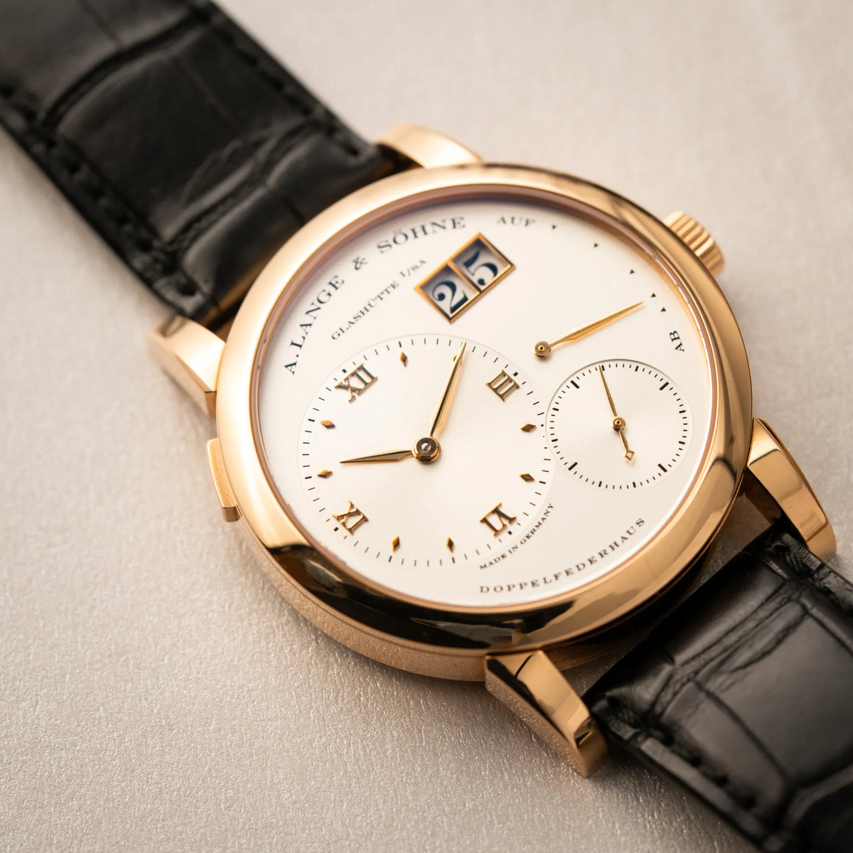 Detailaufnahme der A. Lange & Söhne Lange 1 der Referenz 101.032 mit 38,5mm-Roségold-Gehäuse und dem für das Modell typische, asymmetrisch angeordnete Zifferblatt mit Großdatum
